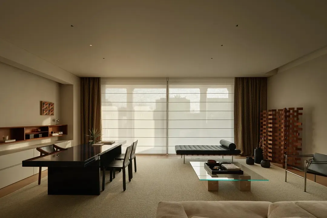 A modern minimalist living room with a neutral-toned color palette and furniture.