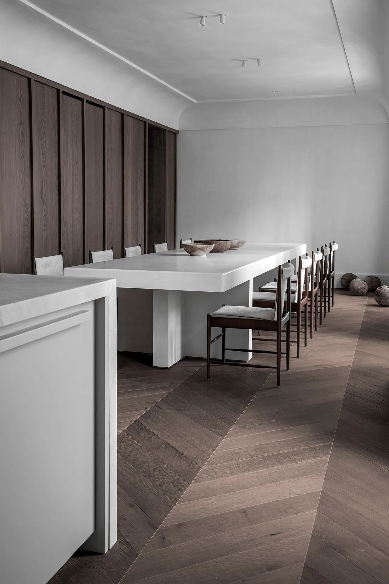 Modern minimalist kitchen with a white concrete table and chairs.