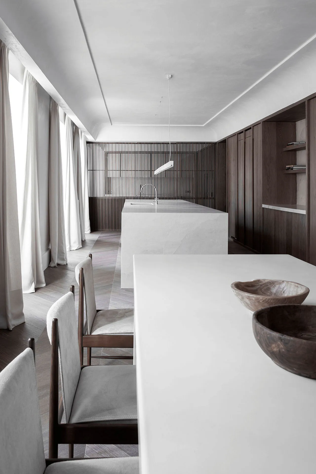 Modern residential kitchen featuring a sleek, minimalist design with a white concrete countertop and wooden elements.