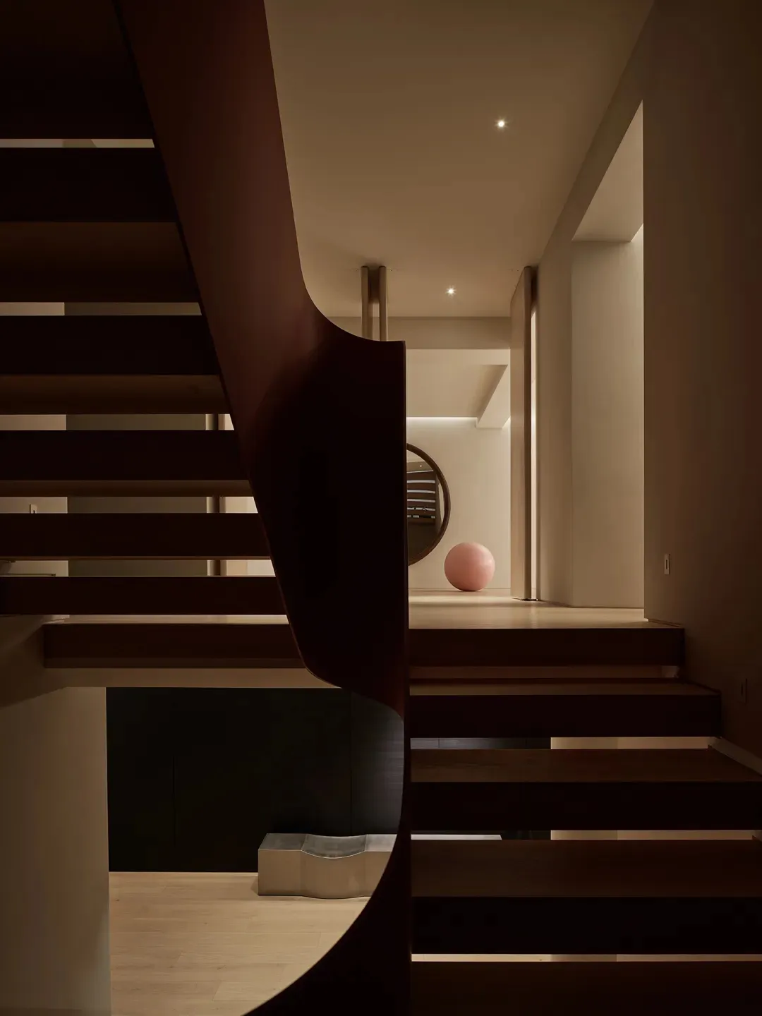 Modern architectural space featuring a curved wooden walkway and stairs.
