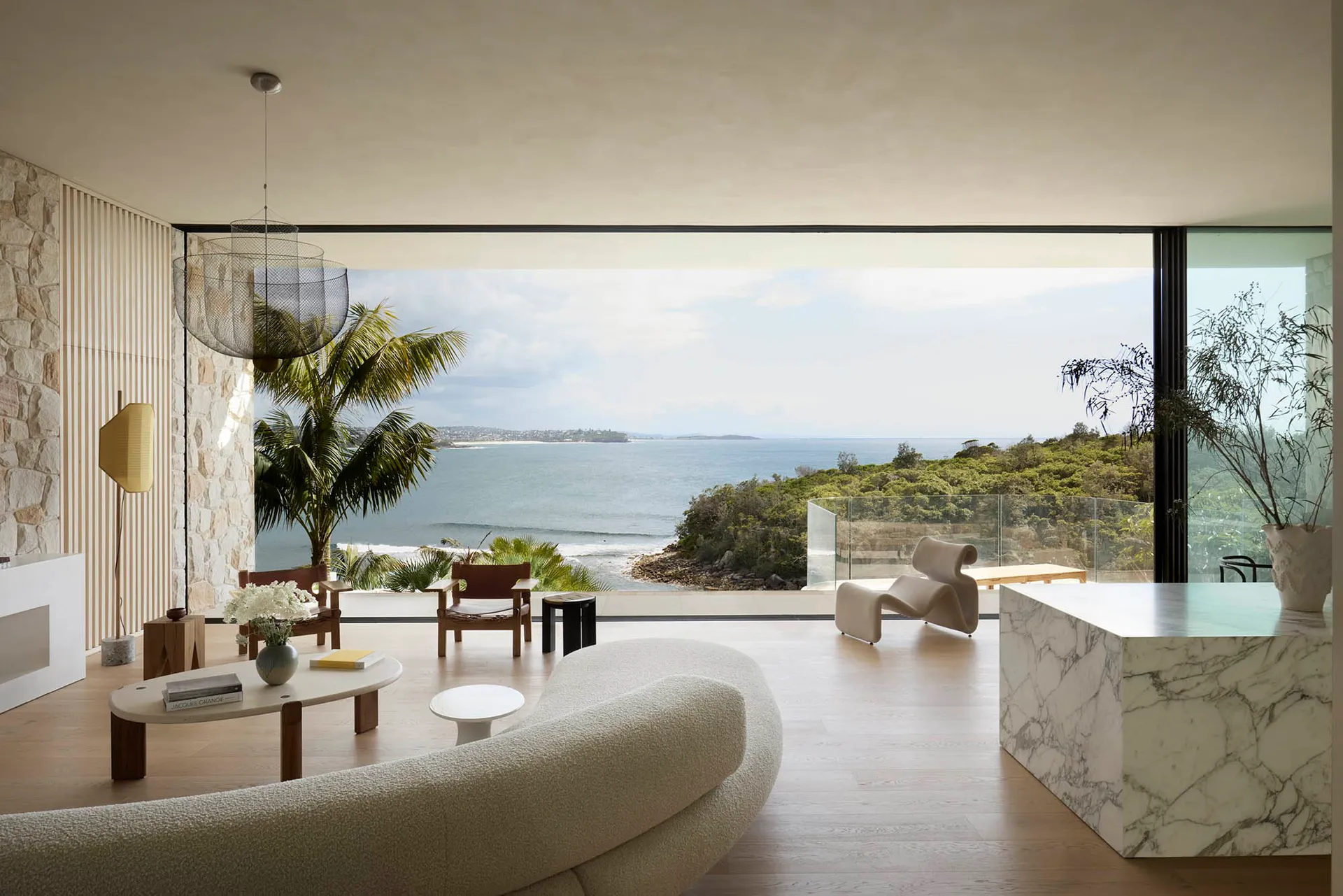 Modern minimalist residential space featuring marble, wood, glass and stone materials.