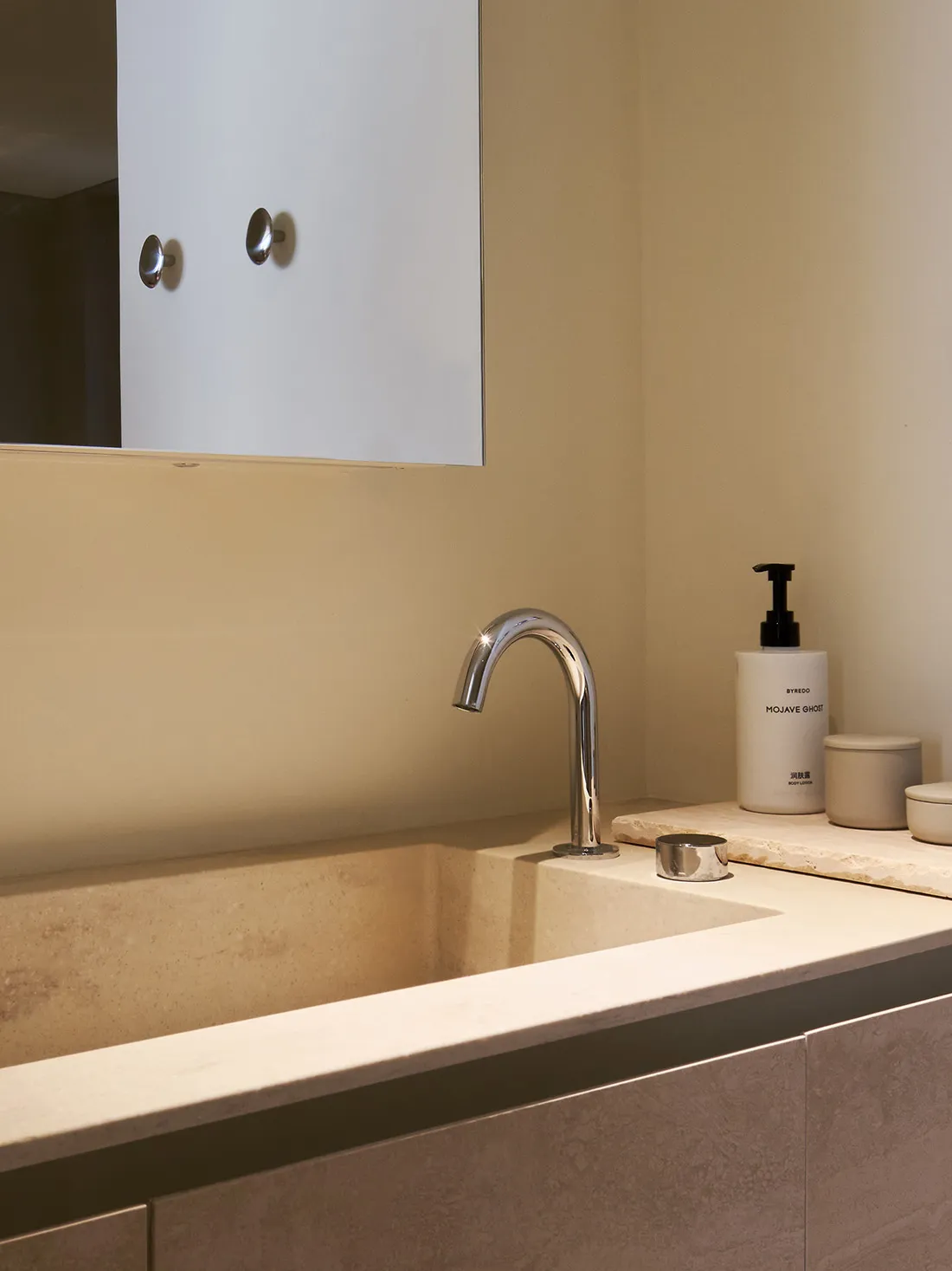 Modern bathroom interior with a white terrazzo countertop and sleek chrome faucet and sink.