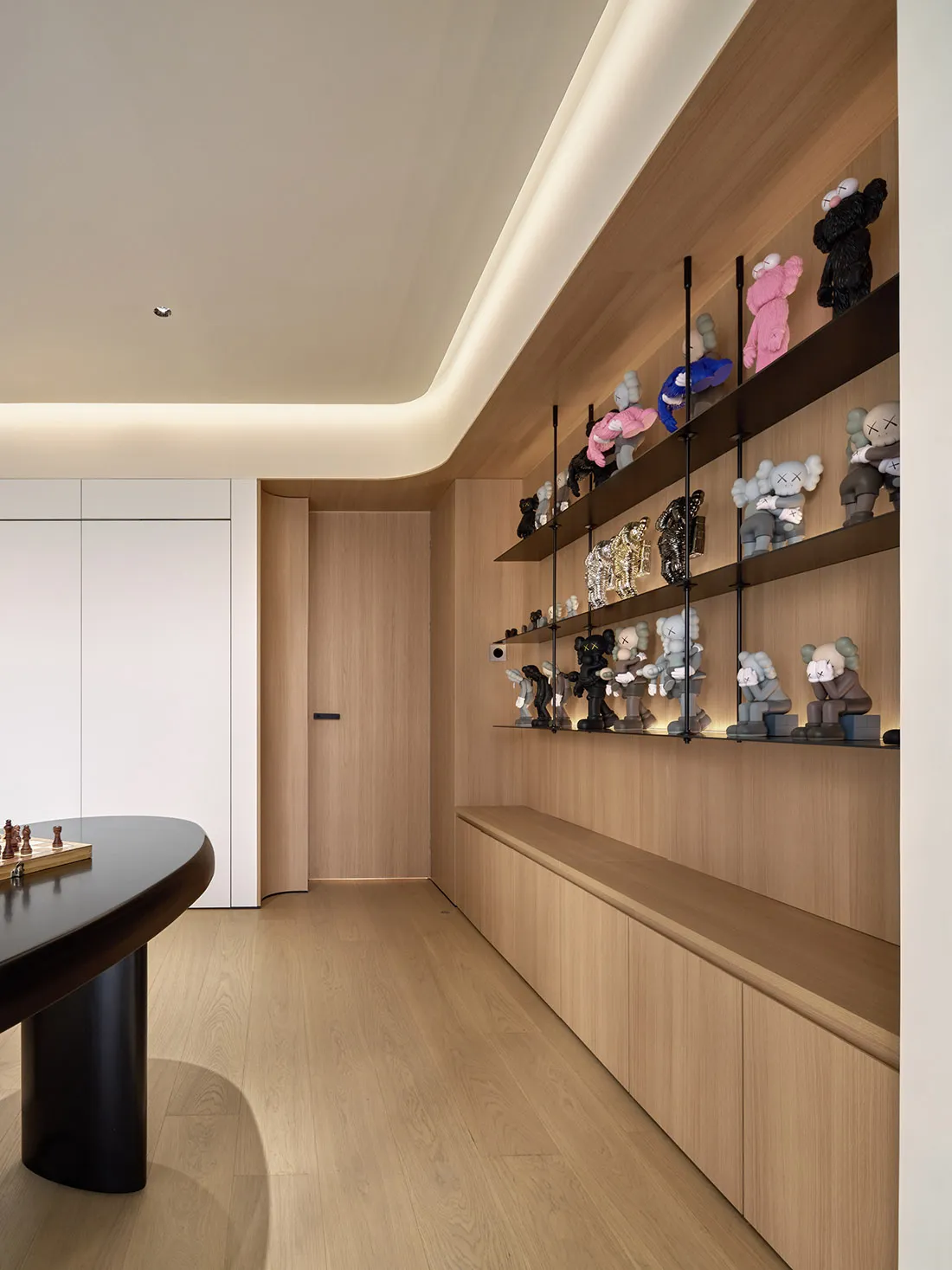 A modern home office with wooden shelves displaying various stuffed animals.