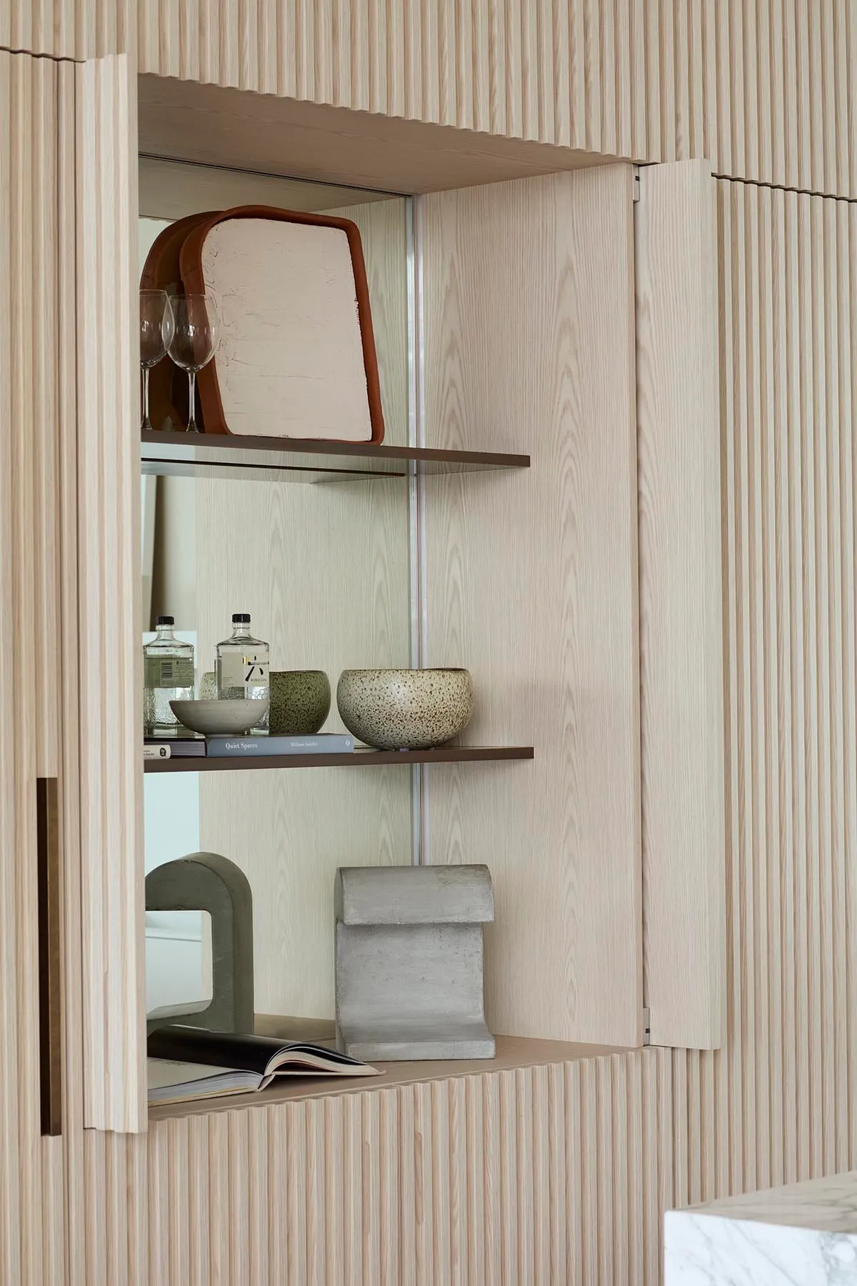 A modern interior design featuring a wooden shelving system with various decorative items.