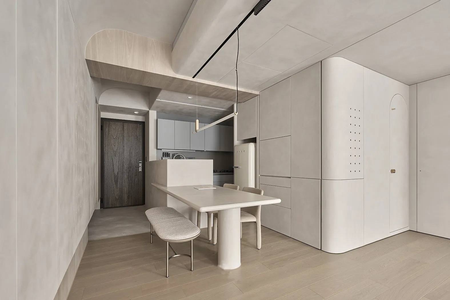 A modern kitchen with minimalist design, featuring a concrete table and bench.