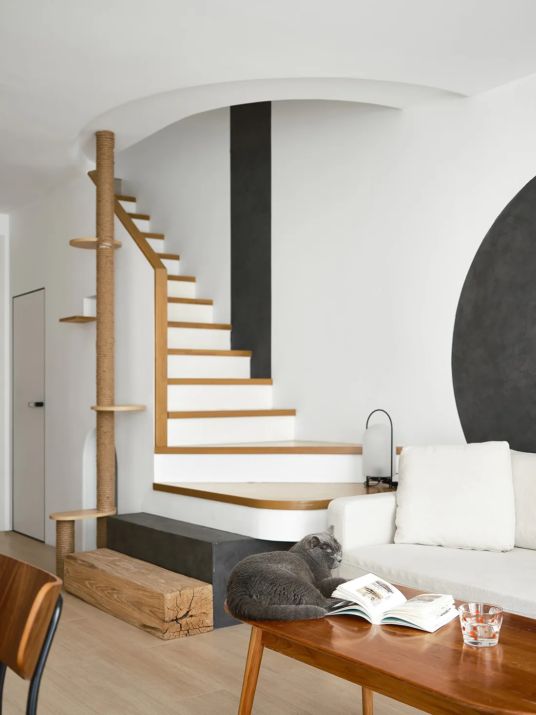 A modern living room featuring a concrete floor, wooden furniture, and glass elements.