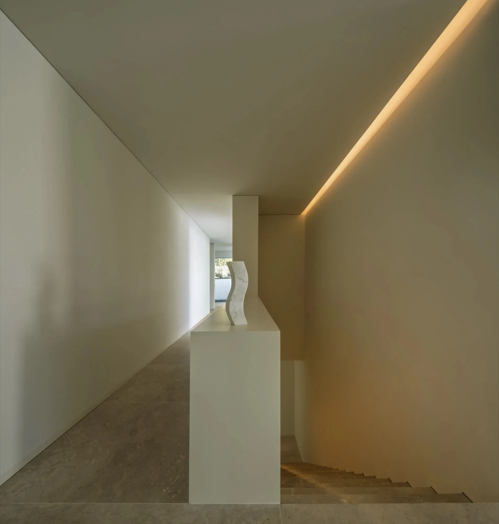 Modern minimalist interior featuring marble elements and warm lighting.