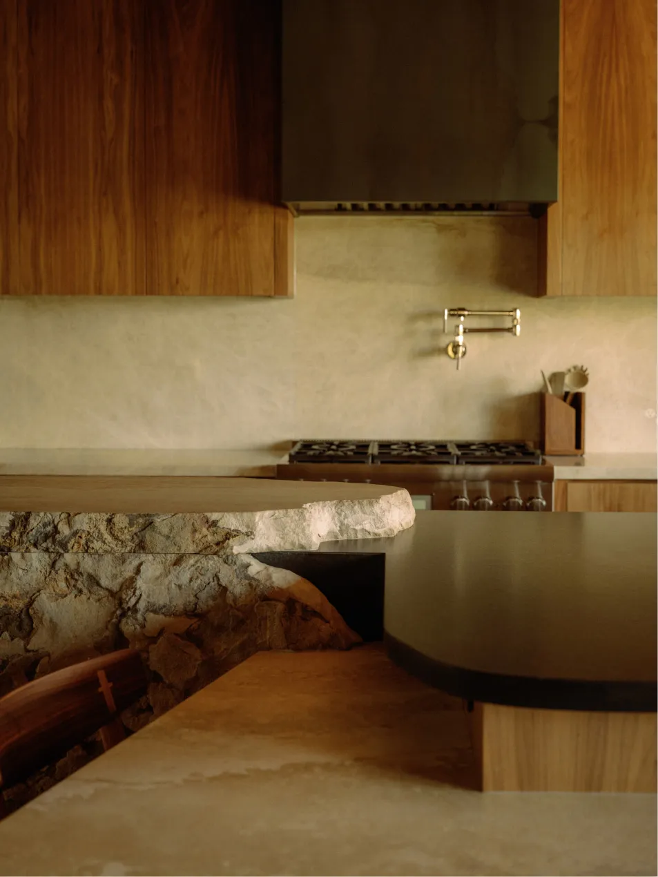Modern kitchen with stone countertop and wooden cabinets.