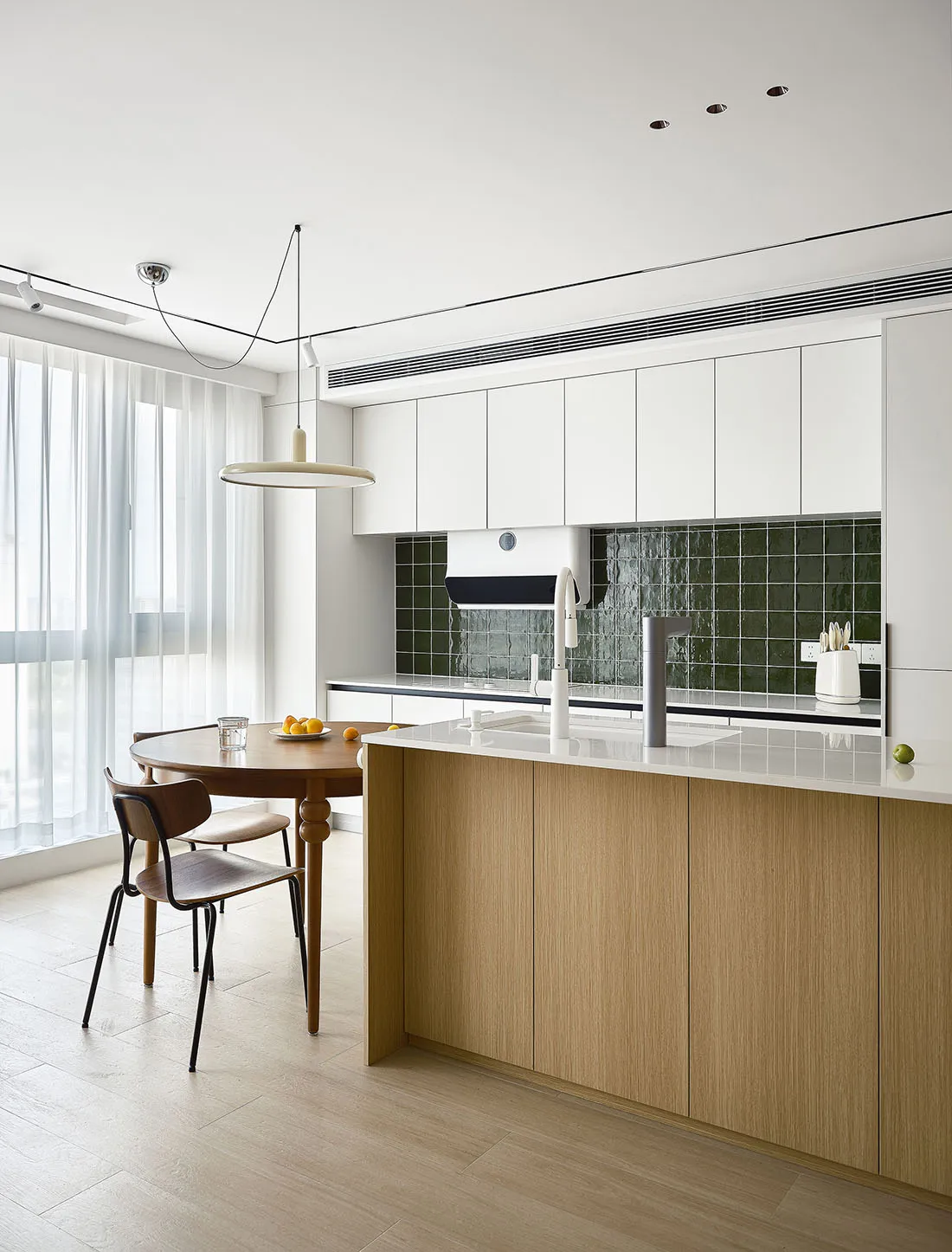 a modern residential kitchen featuring wooden cabinets and glass backsplash.