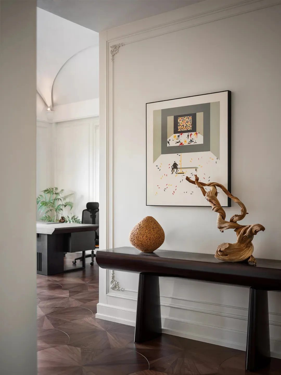 A minimalist interior with a wooden bench, abstract artwork, and natural wood elements.