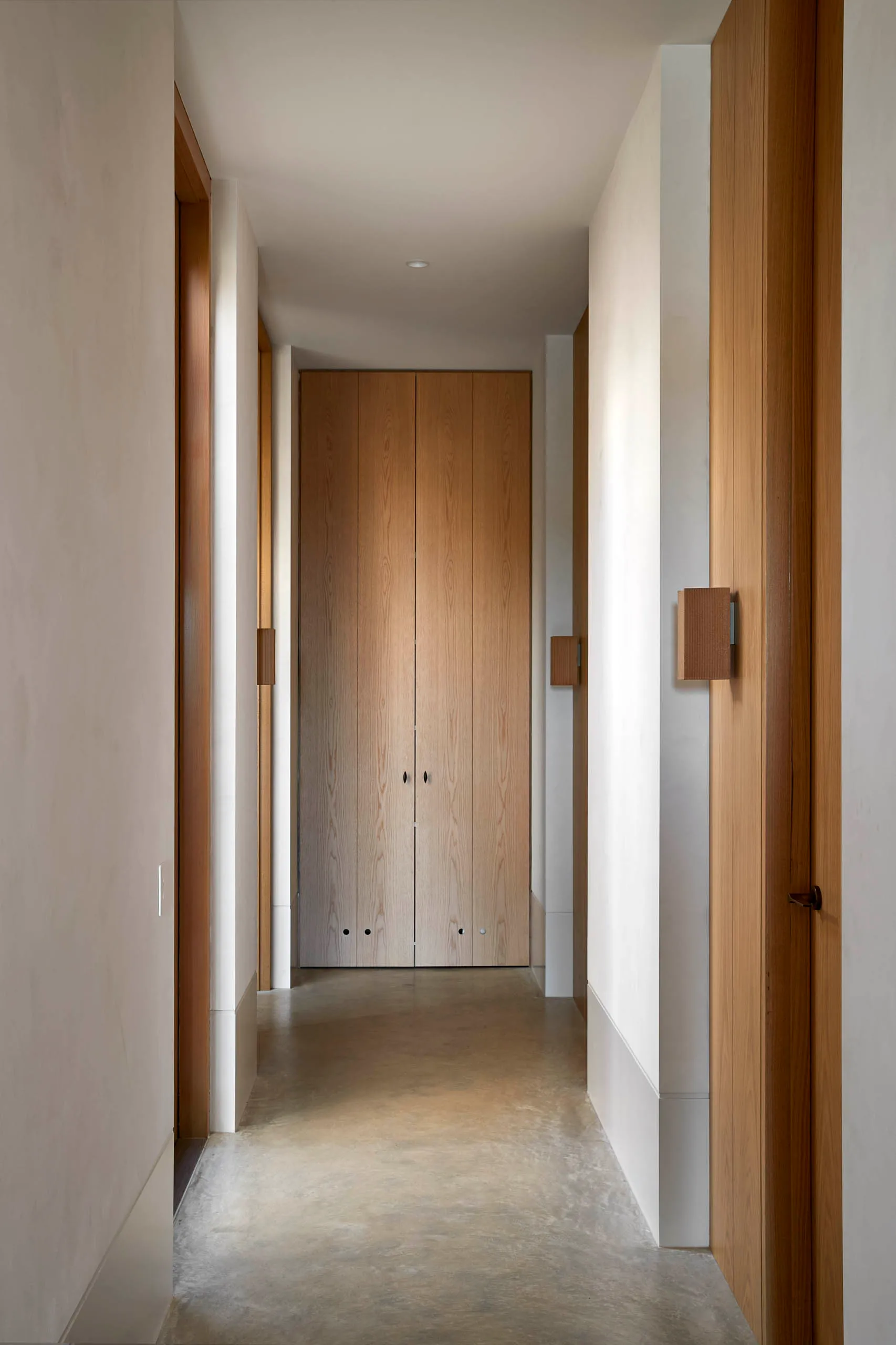 Modern interior design with concrete floor and wooden walls, featuring a minimalist corridor.
