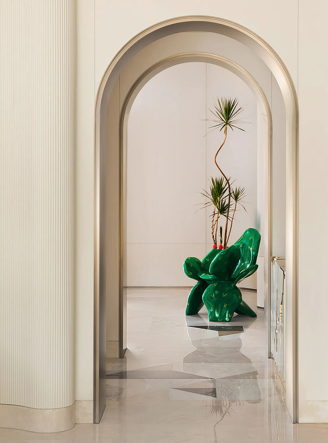 A modern living room featuring marble flooring and a sleek, contemporary cactus-inspired chair with a tall, tall plant in a v
