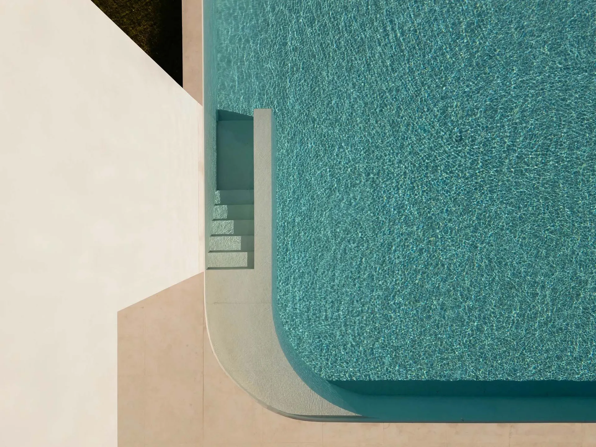 Modern pool with concrete stairs and blue water