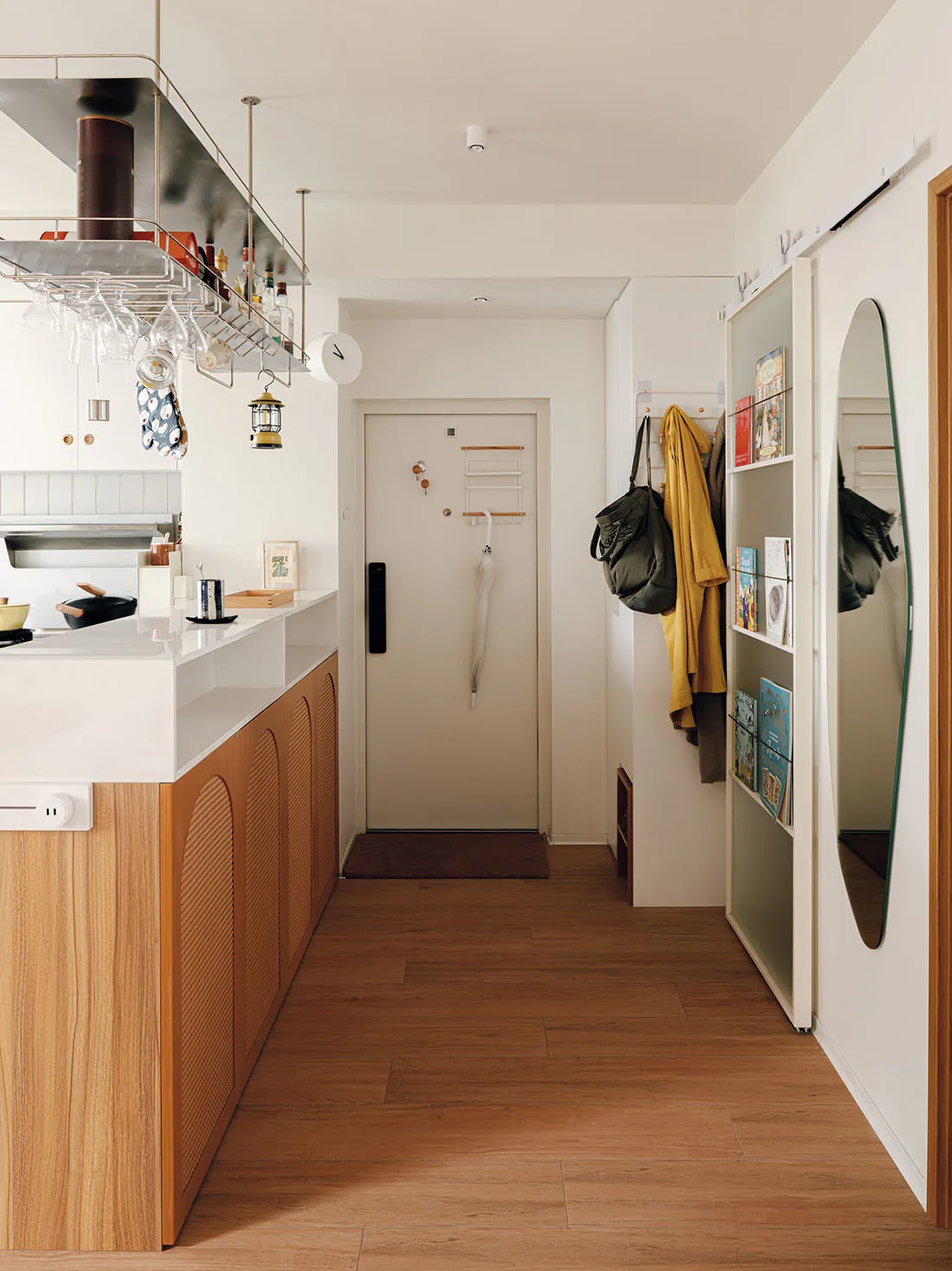 A modern kitchen featuring a wooden countertop with white appliances and various kitchenware hanging above.