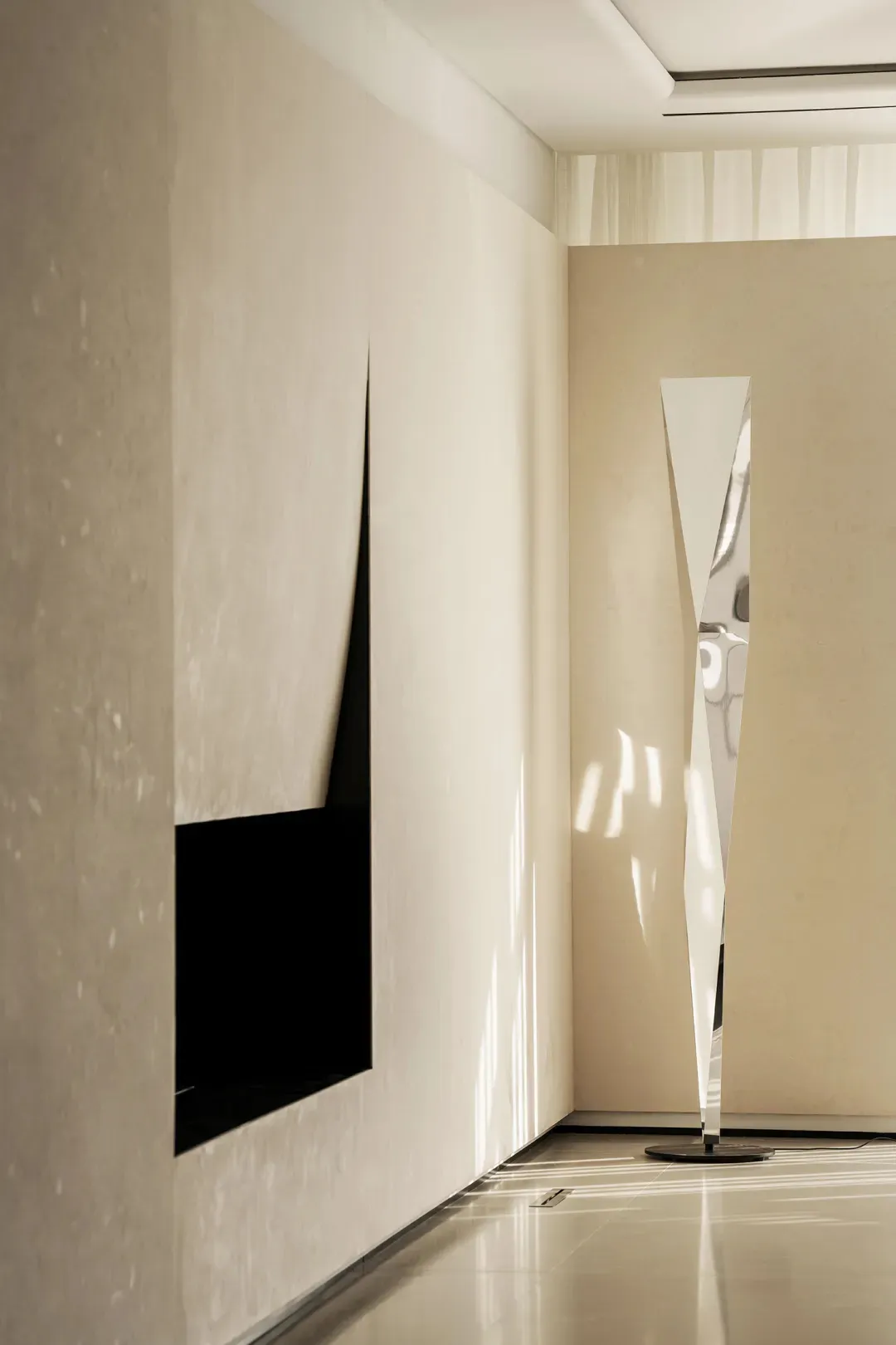 A modern interior design featuring a glass window and a tall, modern mirror with a geometric design.