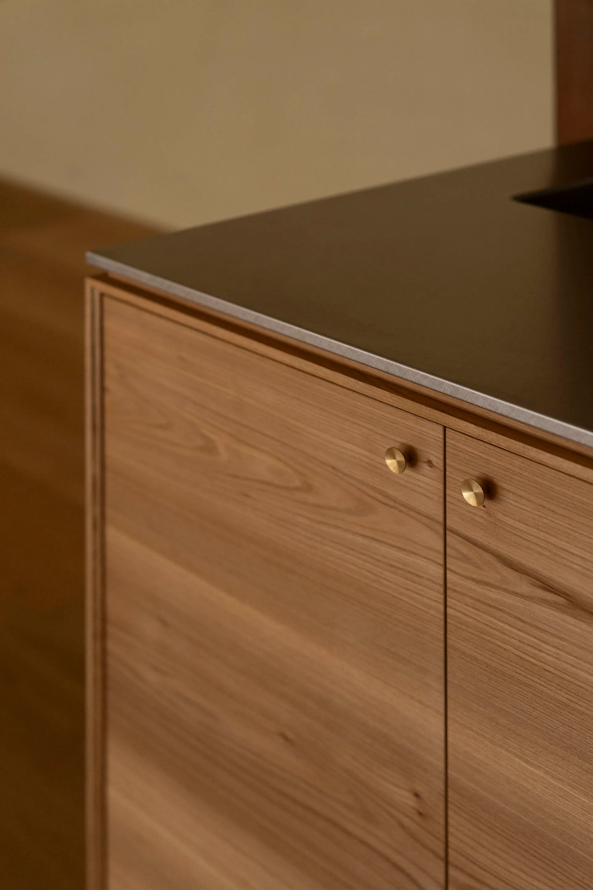 Modern minimalist kitchen featuring wooden cabinetry and a sleek, minimalist design.