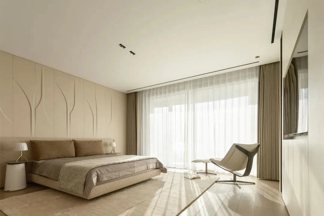 A modern bedroom with neutral-toned textiles and fabrics, highlighting minimalist design elements and a serene, sophisticated