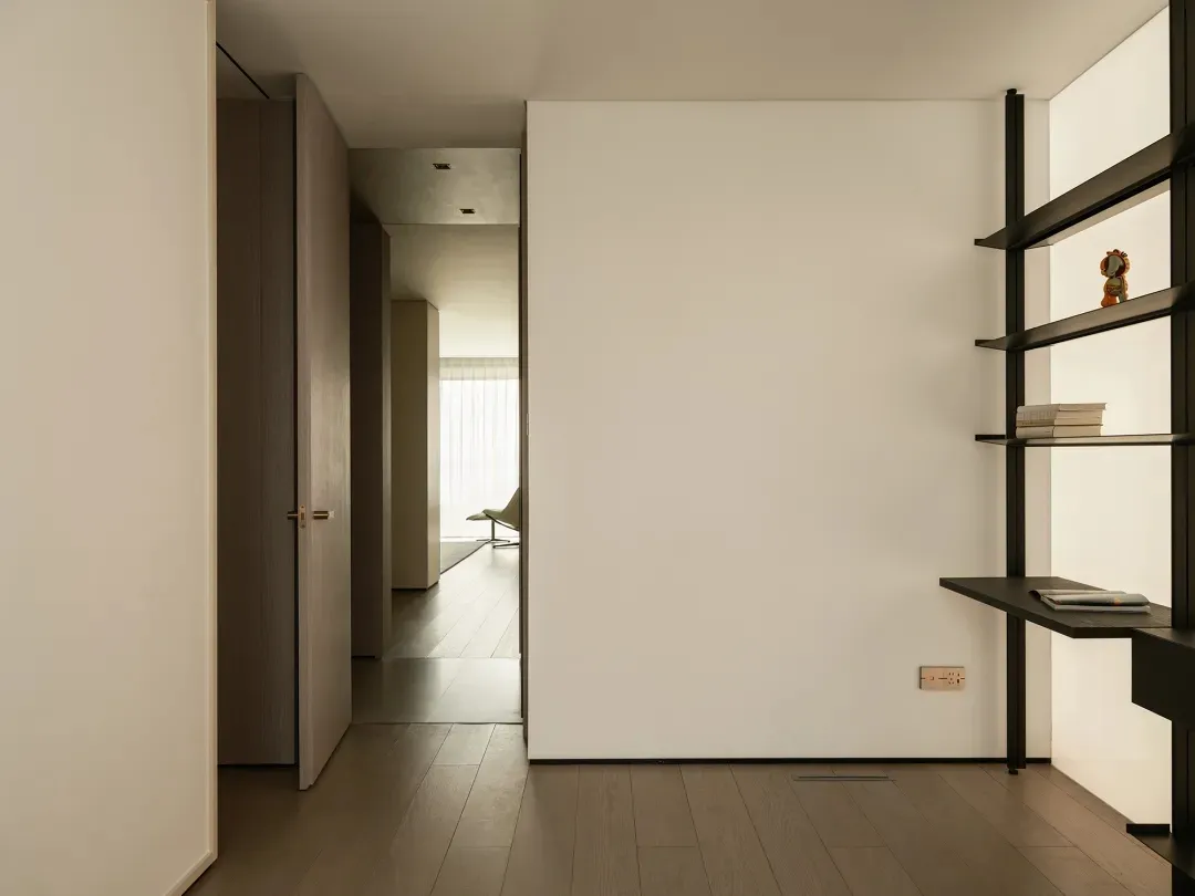 Spacious, minimalist-style living room with a wooden floor and white walls.