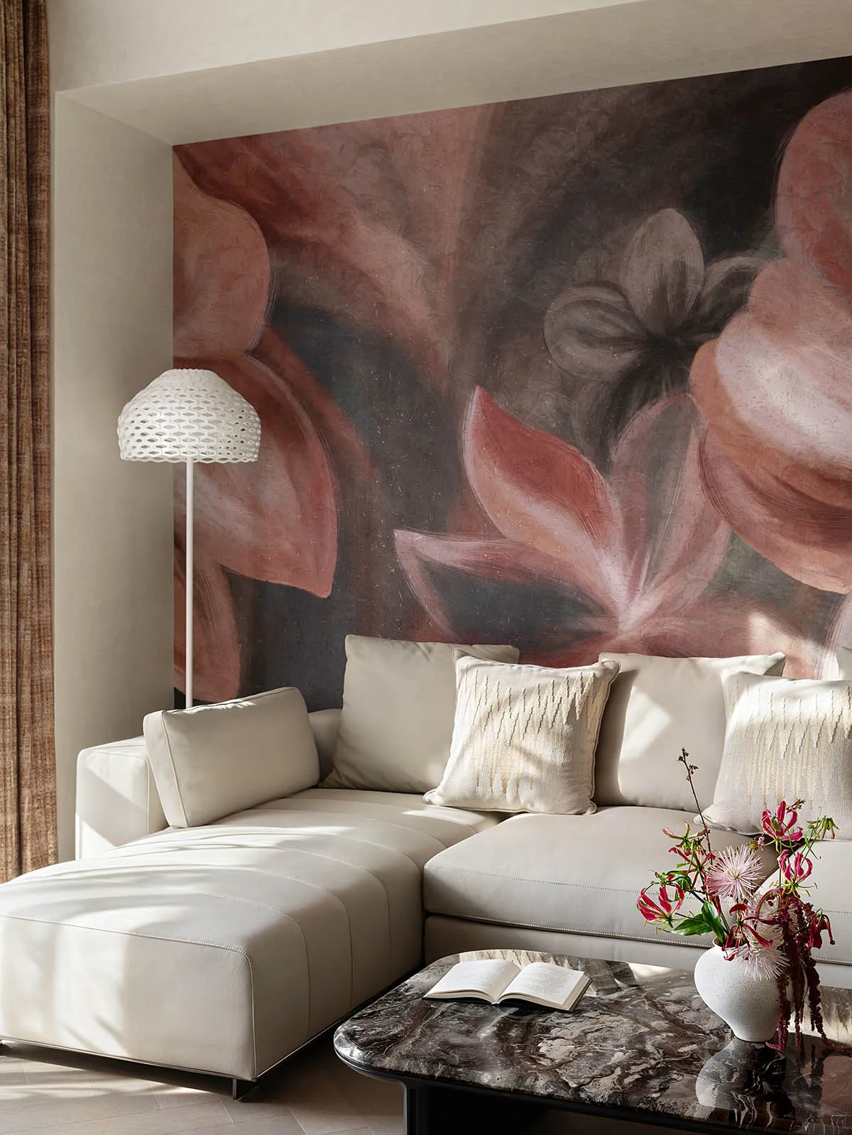 Contemporary living room featuring a modern sofa with floral mural backdrop, white floor lamp, and marble coffee table with a