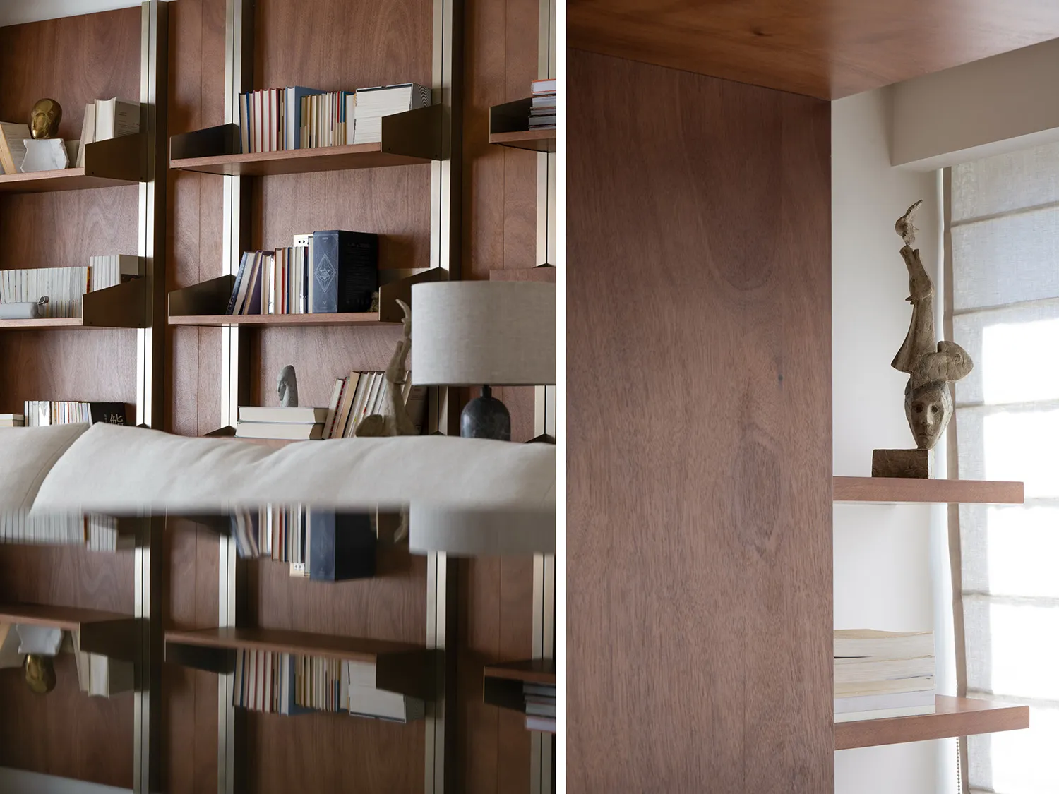Modern, minimalist interior with wood shelves containing books and sculptures.