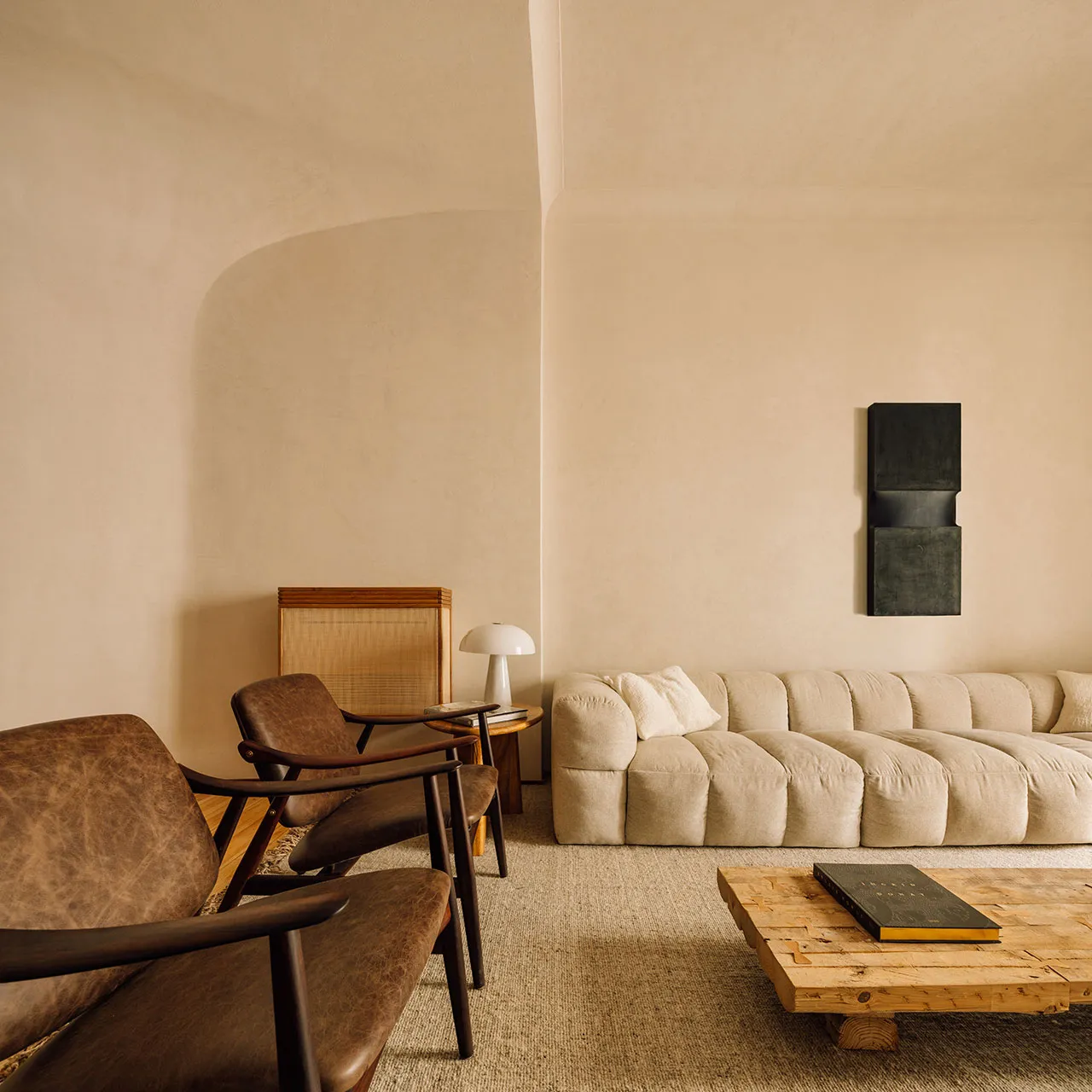 A textured living room featuring a comfortable sofa with neutral tones and a wooden coffee table.