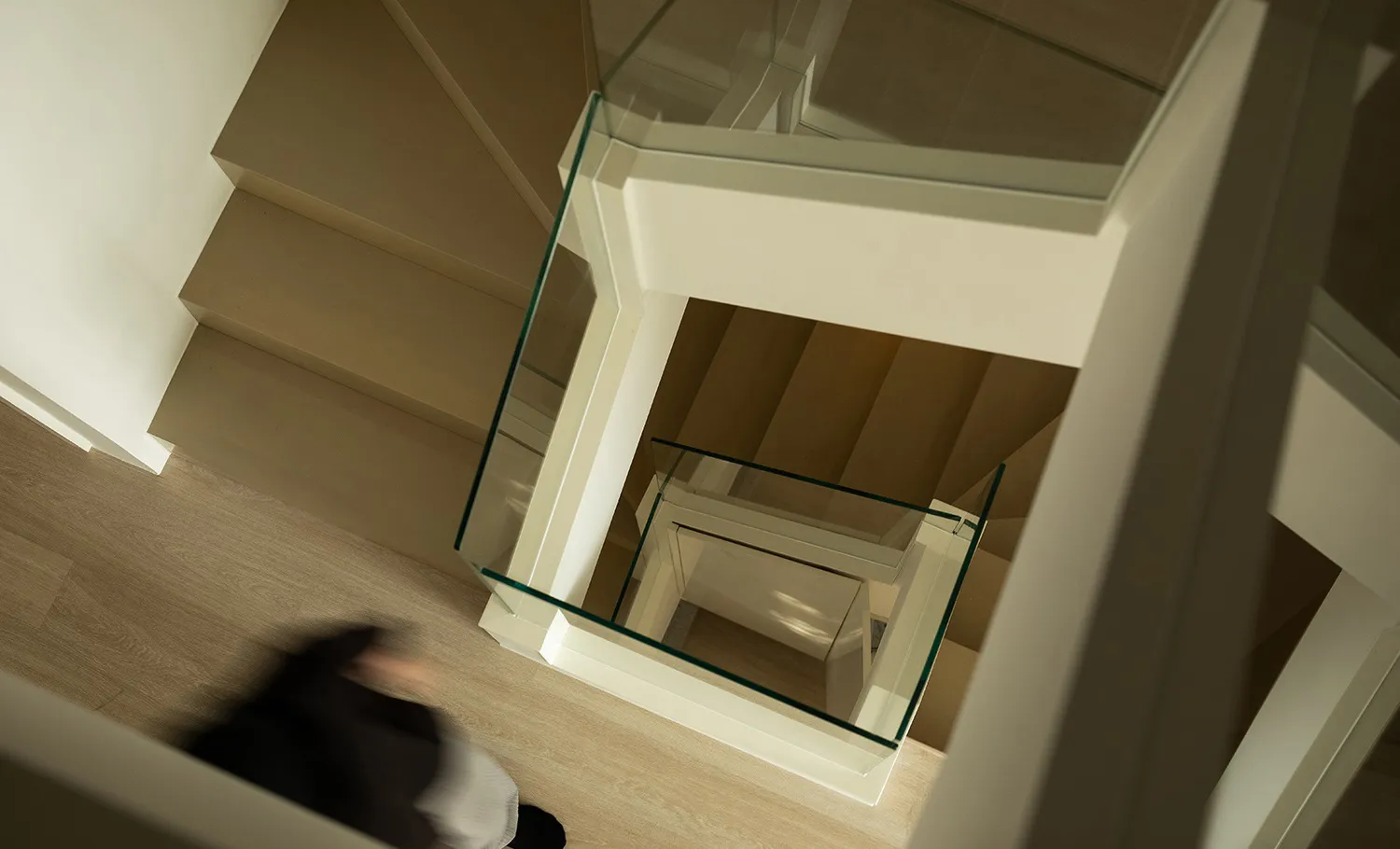A modern interior space with a glass staircase.
