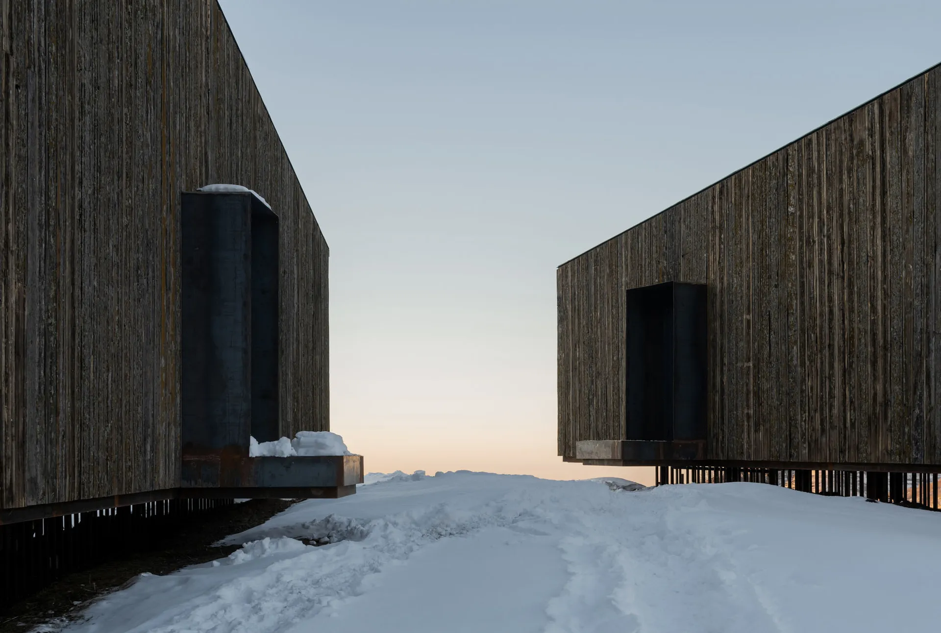 Modern architectural structures with snow-covered exterior and steel elements.