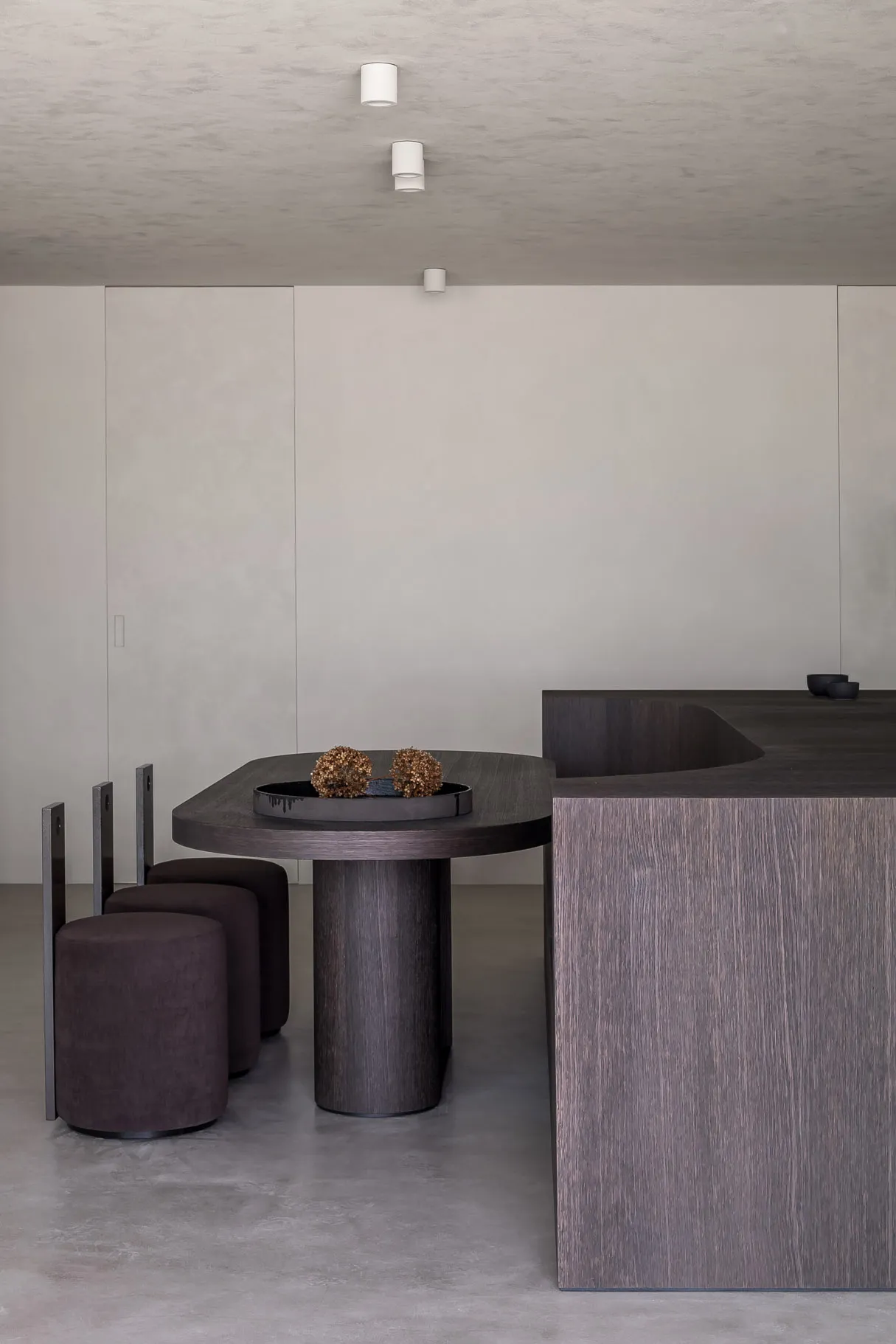 Modern minimalist dining space featuring wood and concrete materials and design.
