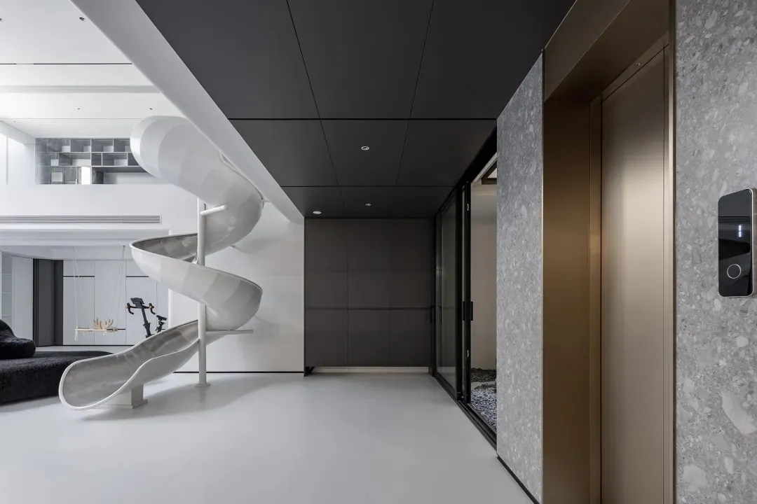 Modern playroom featuring a sleek, metallic slide and white floor tiles.