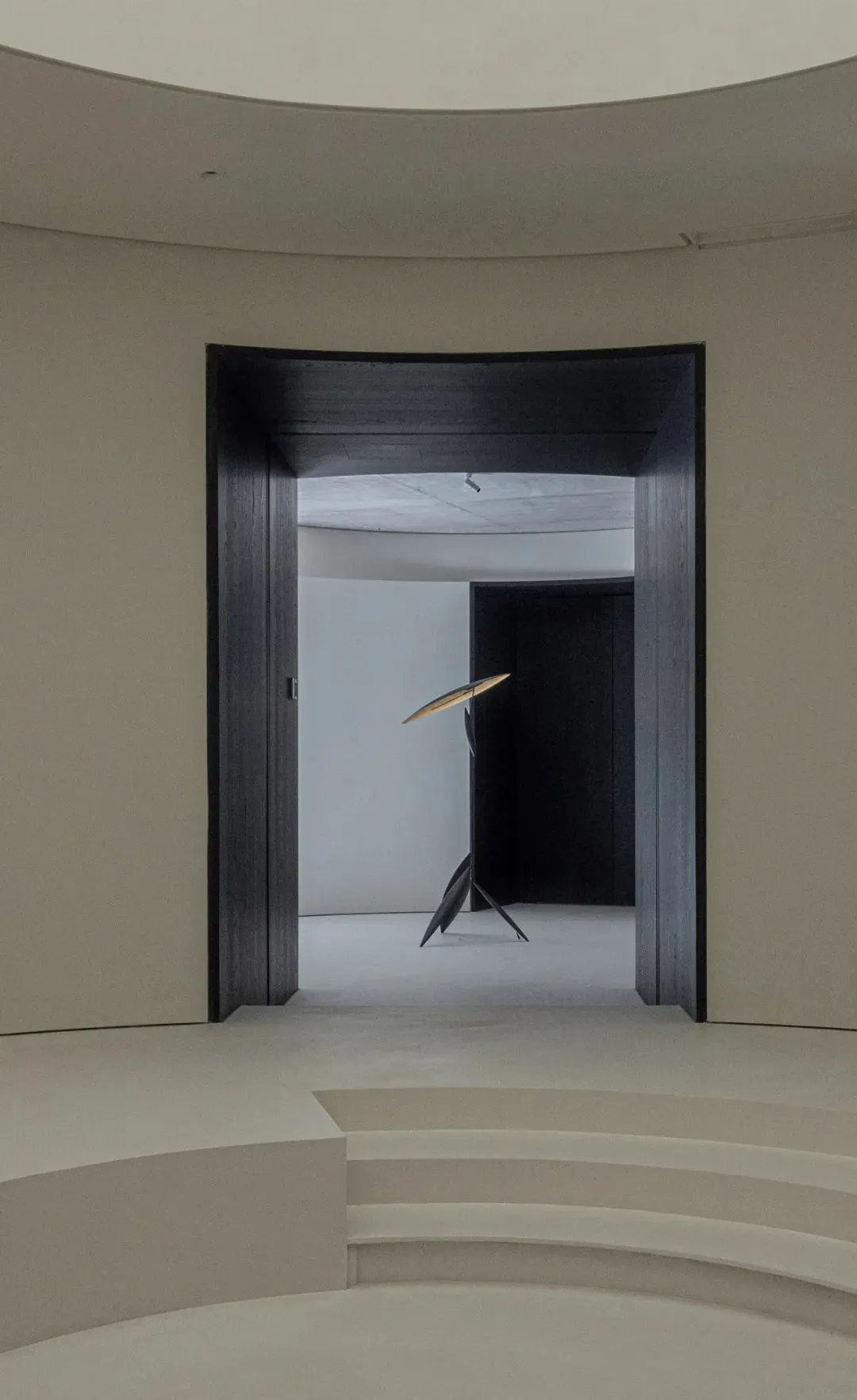 Minimalist showroom interior with metallic lighting fixture.