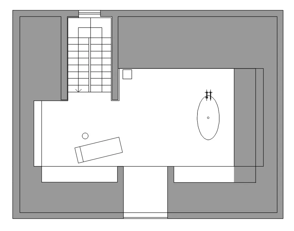 A minimalist bedroom with white walls and a wooden floor.