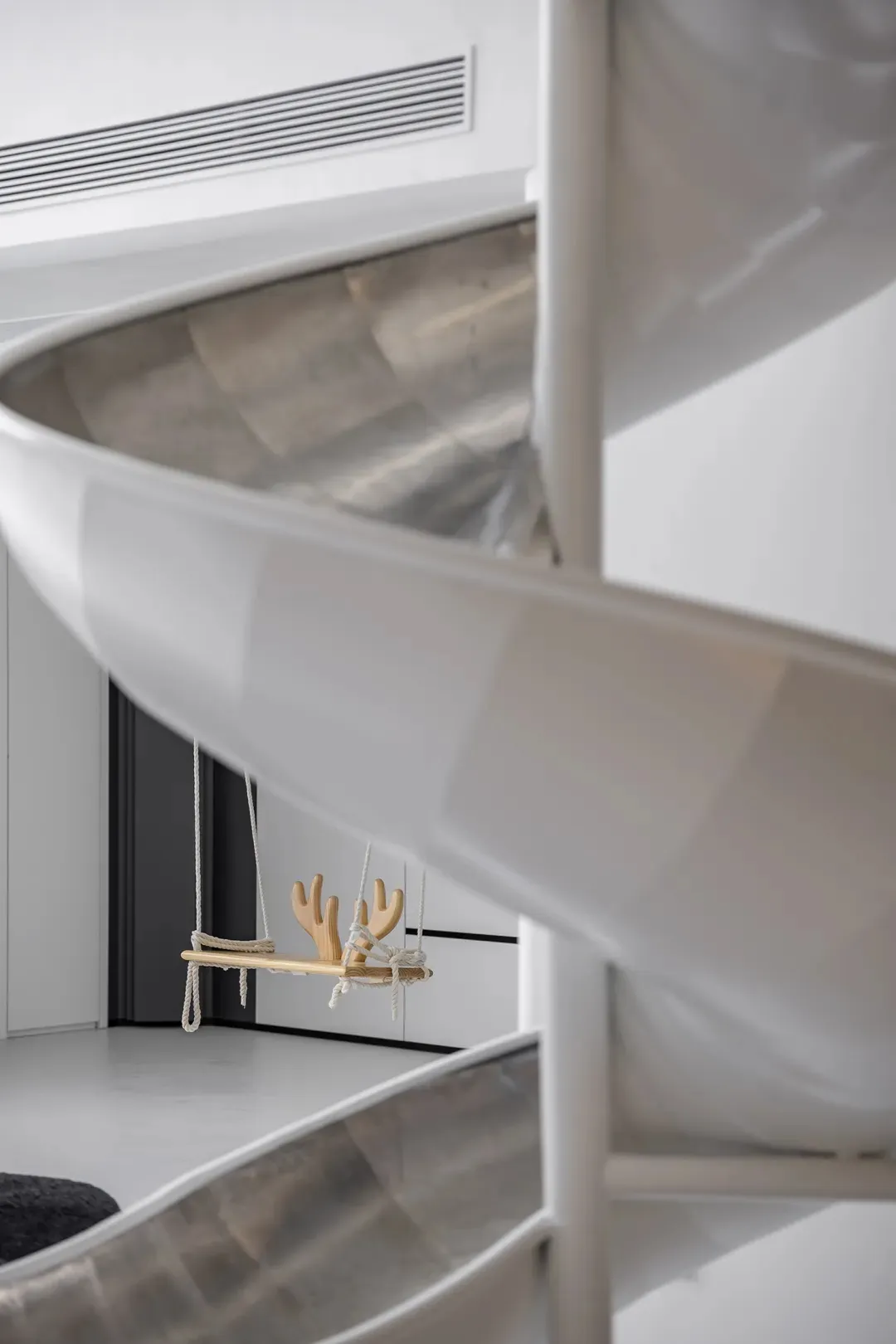 Modern minimalist interior design featuring a white spiral staircase with a metal handrail.