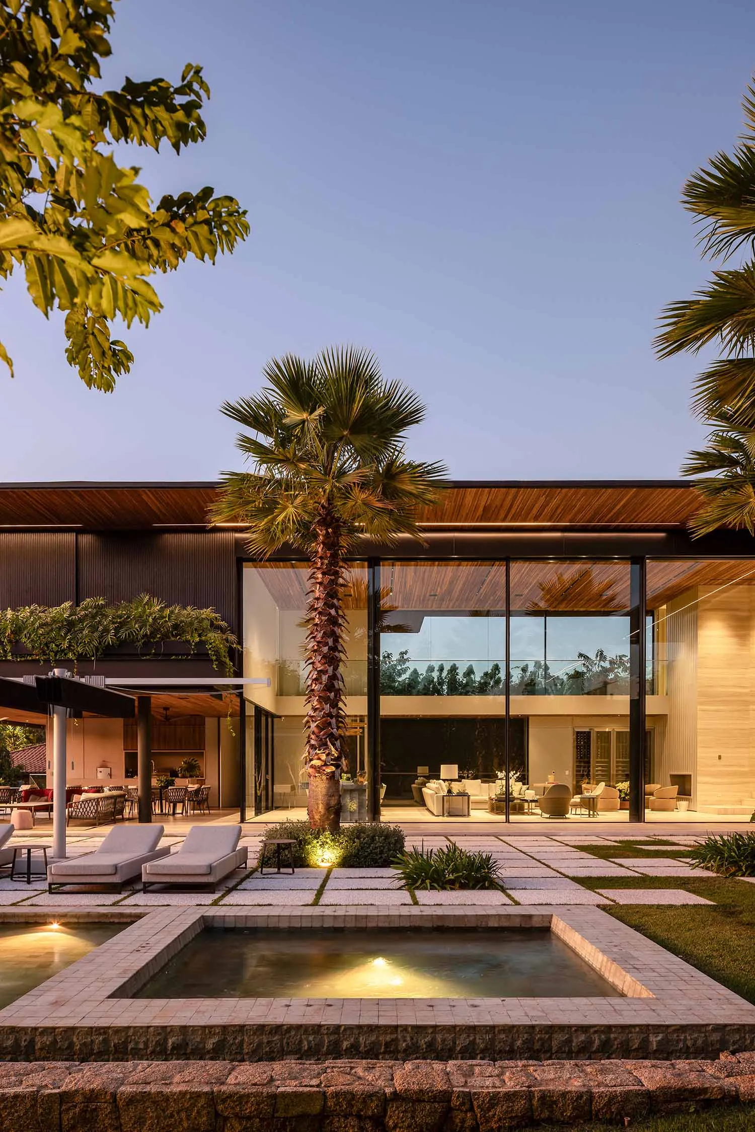 Modern residential exterior featuring a contemporary design with glass, stone, and concrete materials.