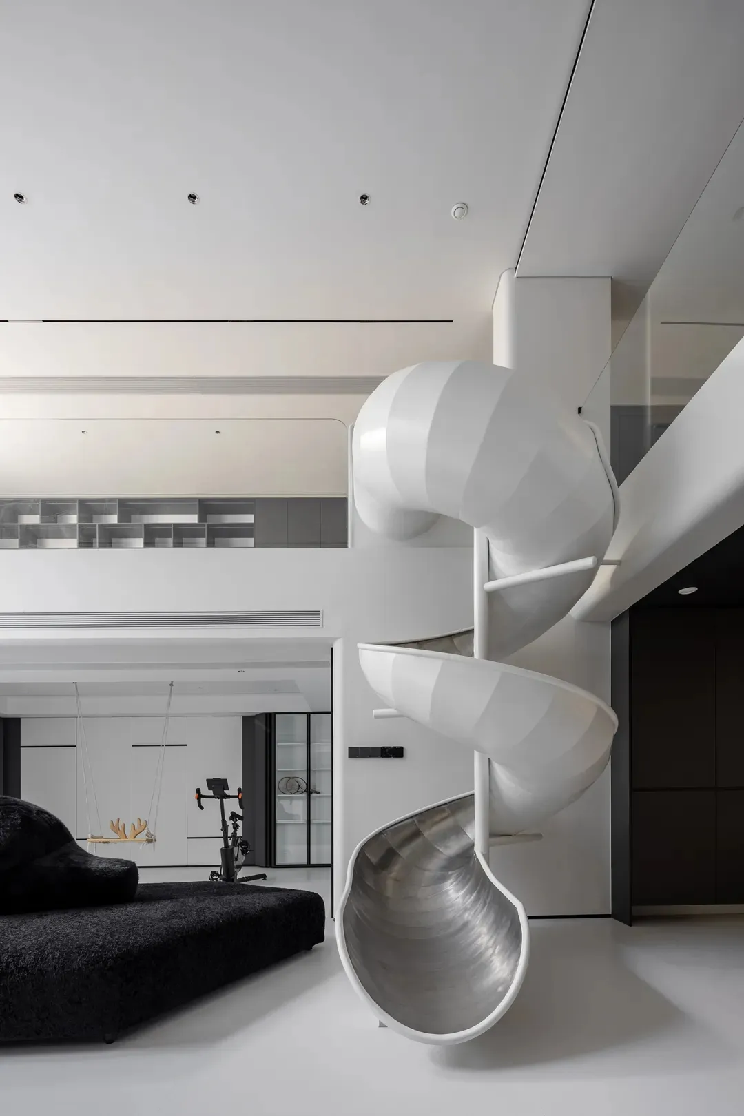 White minimalist living room with a large, modern, white metal slide.
