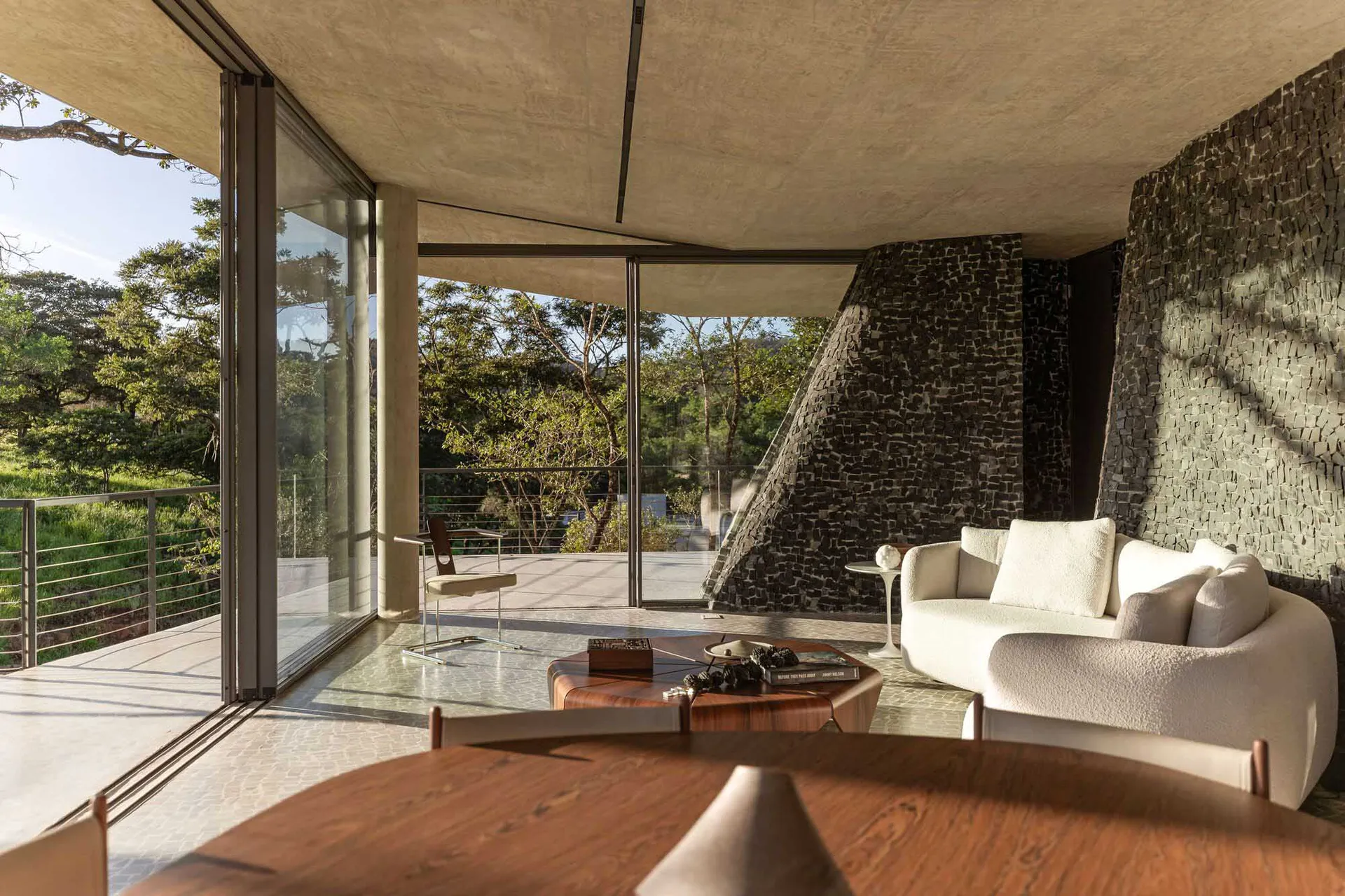 Modern living room with minimalist design, featuring large windows and a white sofa.
