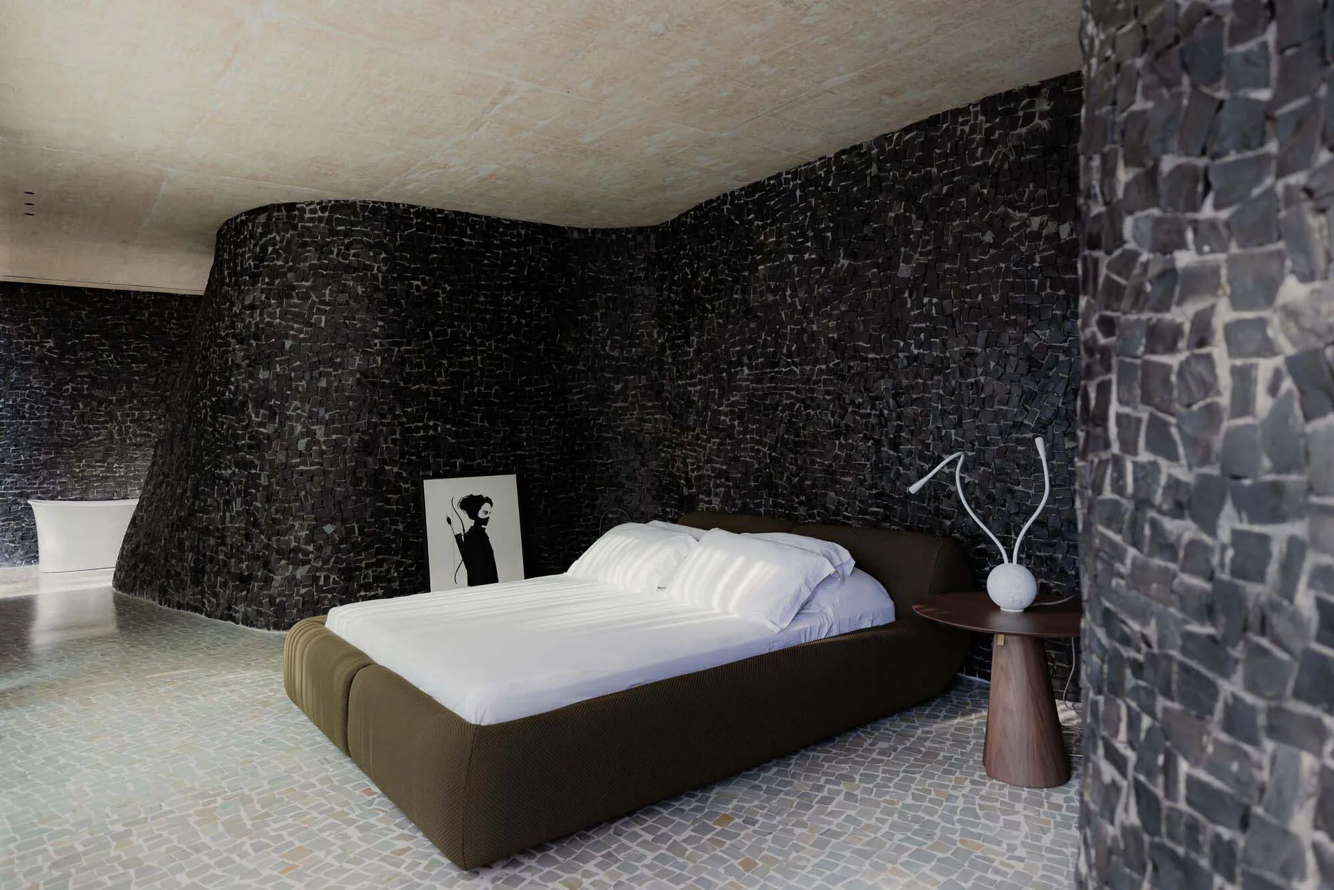 Modern bedroom with minimalist design featuring a concrete wall and floor.