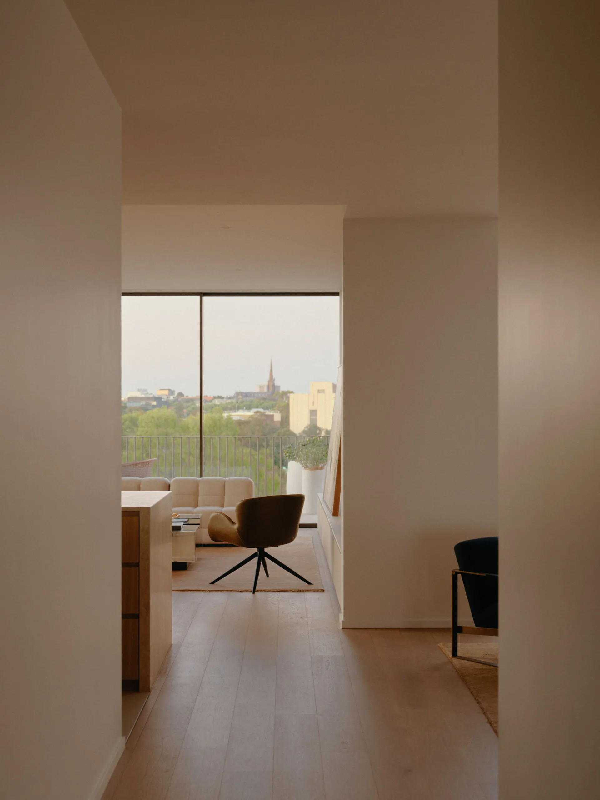 Spacious minimalist living room with wood flooring and leather furniture, showcasing modern design elements and space-saving
