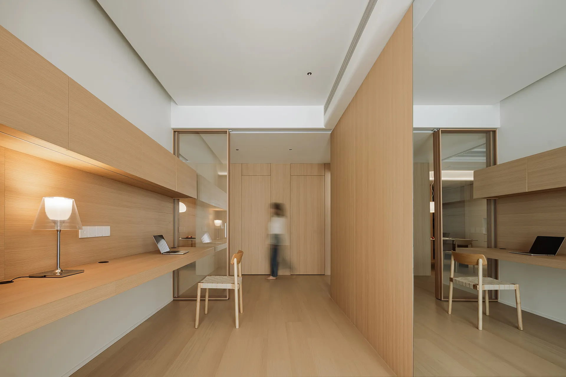 A minimalist office space featuring wooden furniture and a modern design.