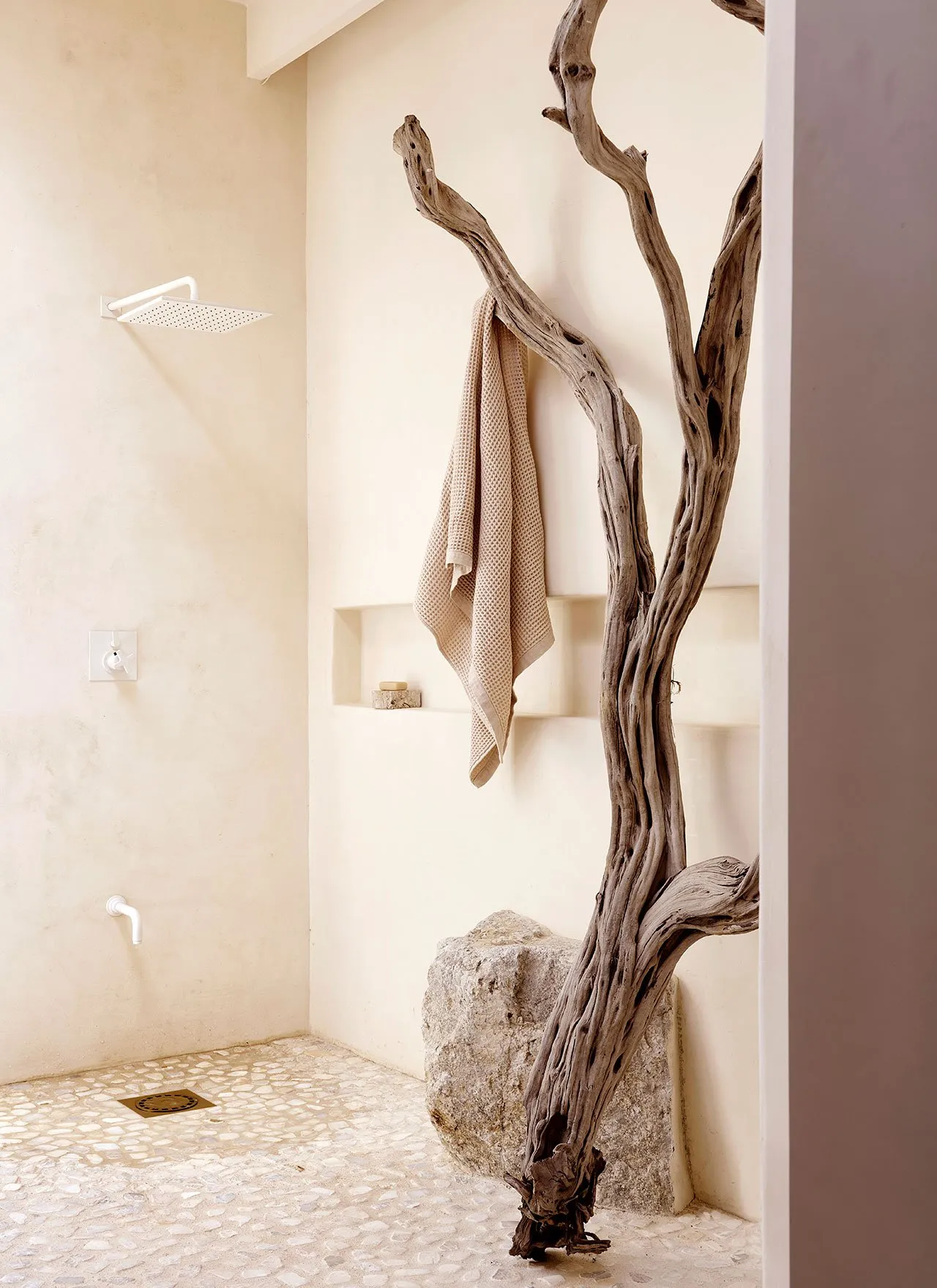 Modern minimalist bathroom with stone wall and tree branch