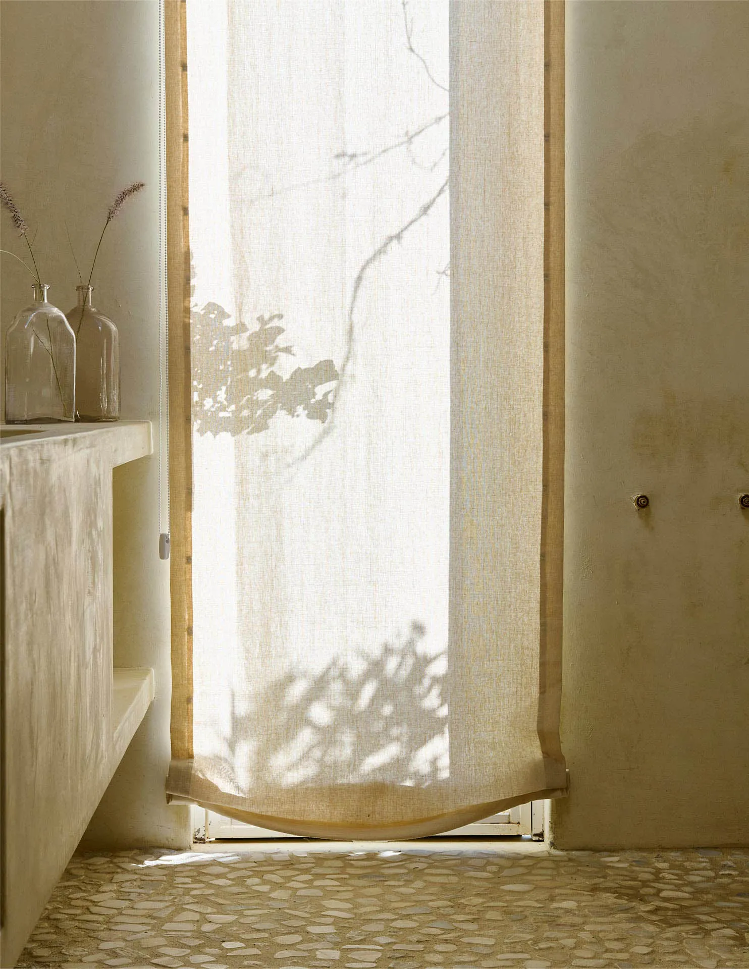 A minimalist-style curtain made of fabric, with a window and a wooden frame in the background.