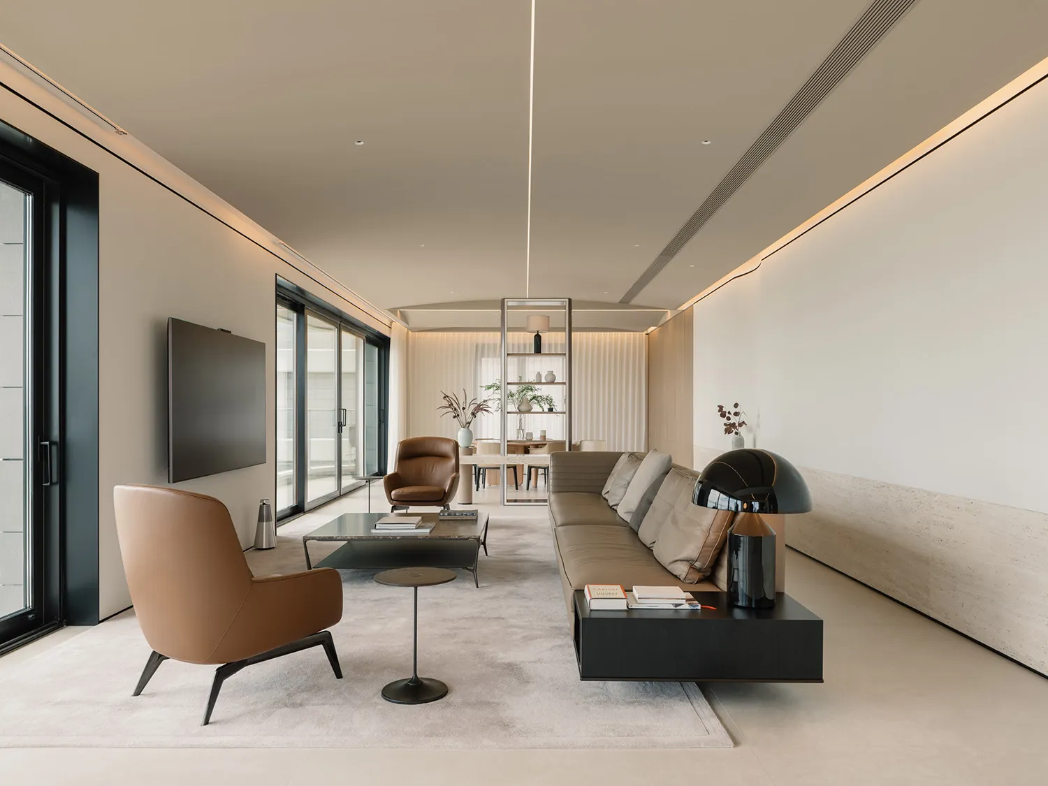 Modern living room with leather sofas, glass coffee table, and wooden accents.