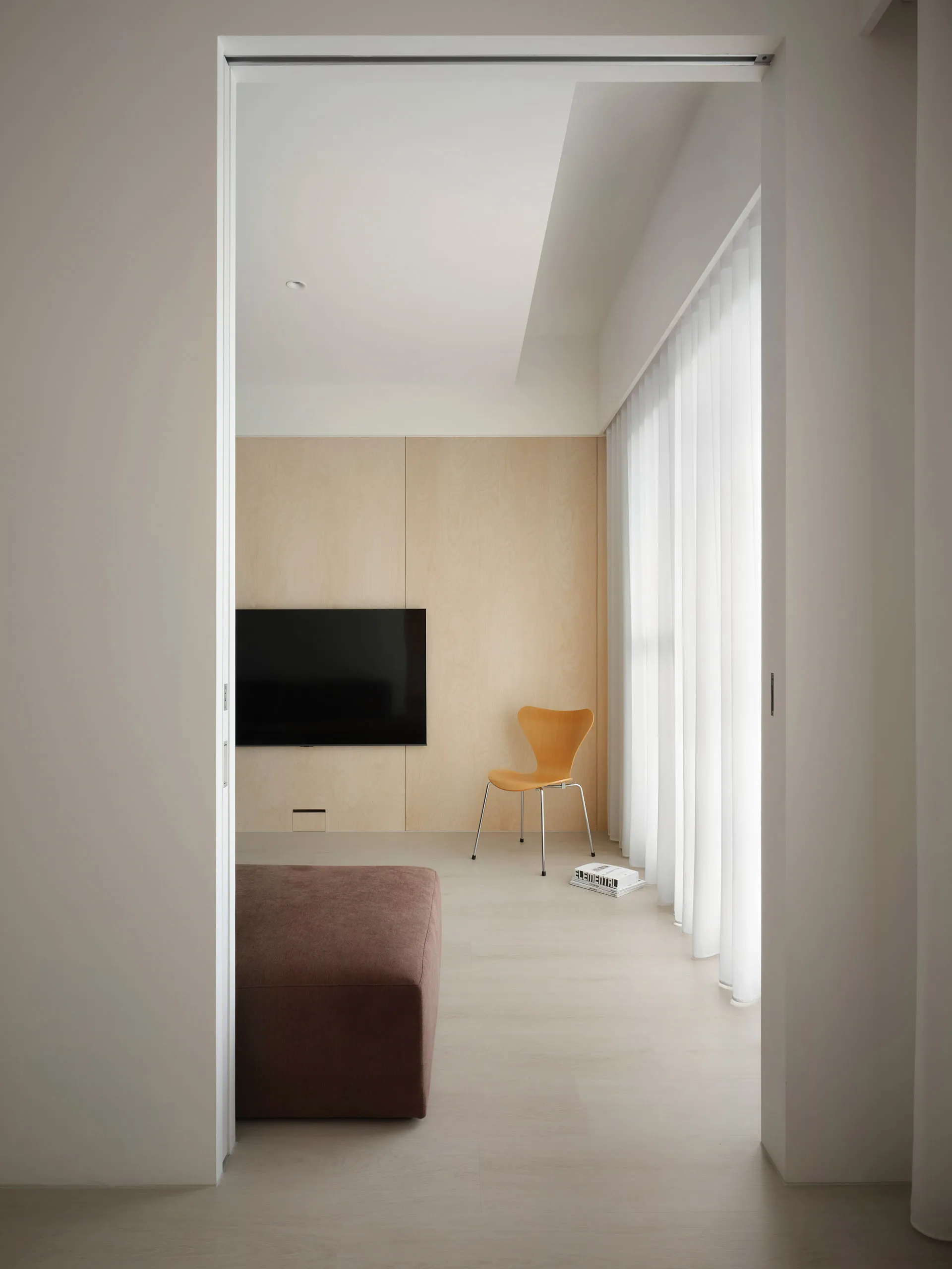 A modern minimalist living room with wooden elements and a sleek, stylish interior.