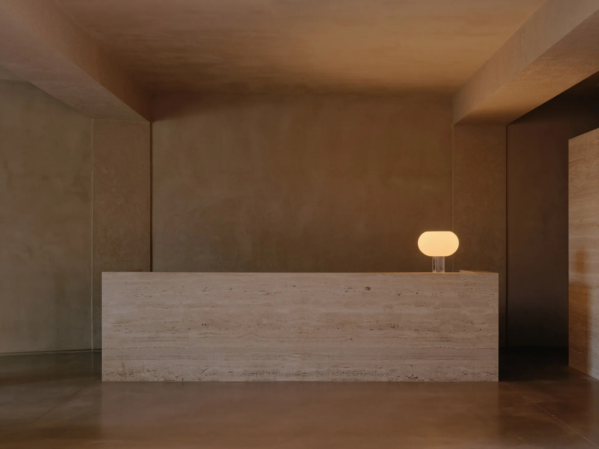 Minimalist reception desk with stone material in a minimalist interior design setting.