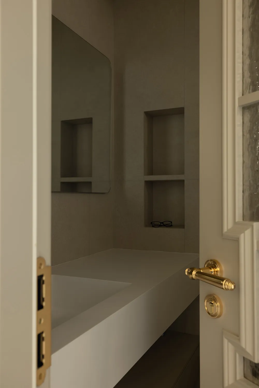 A modern bathroom with concrete walls and a built-in vanity.