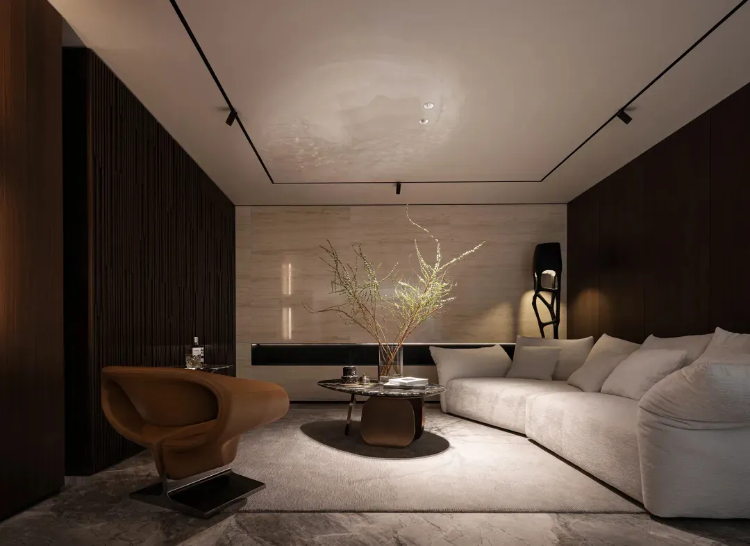 A modern living room featuring a white sofa, brown armchair, and minimalist decor with neutral-toned walls and floor.