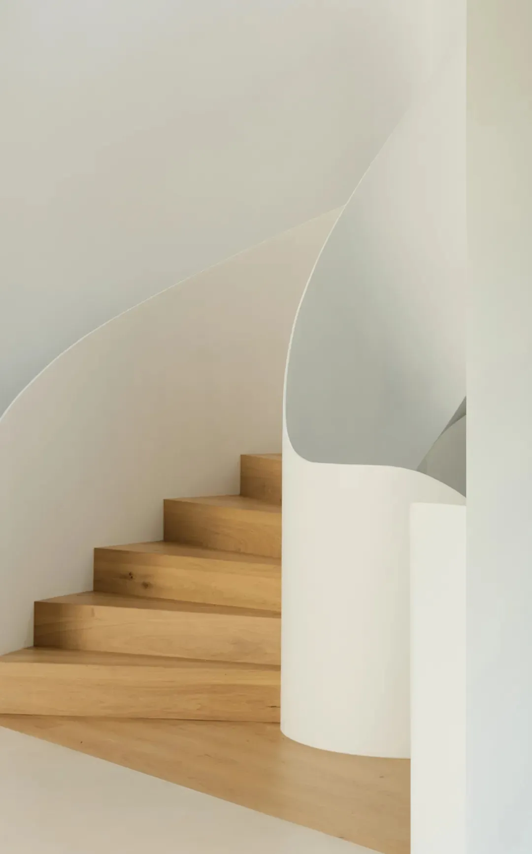 A minimalist interior space featuring white wooden steps and a white wall.