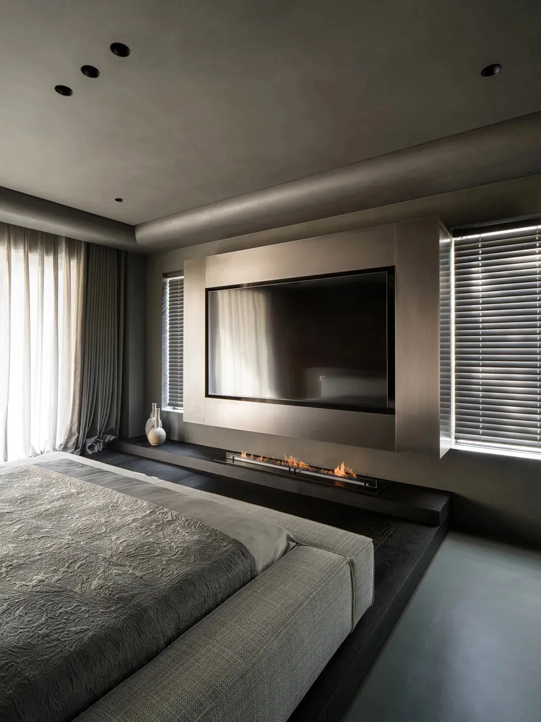 A modern bedroom featuring metallic elements and a large flat-screen television.