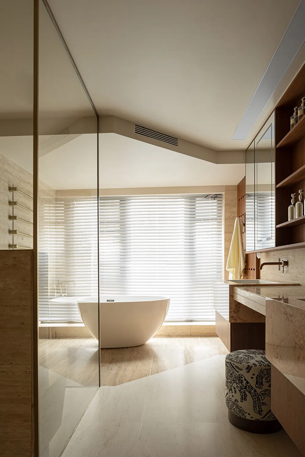 Modern minimalist bathroom featuring white marble walls and a freestanding bathtub