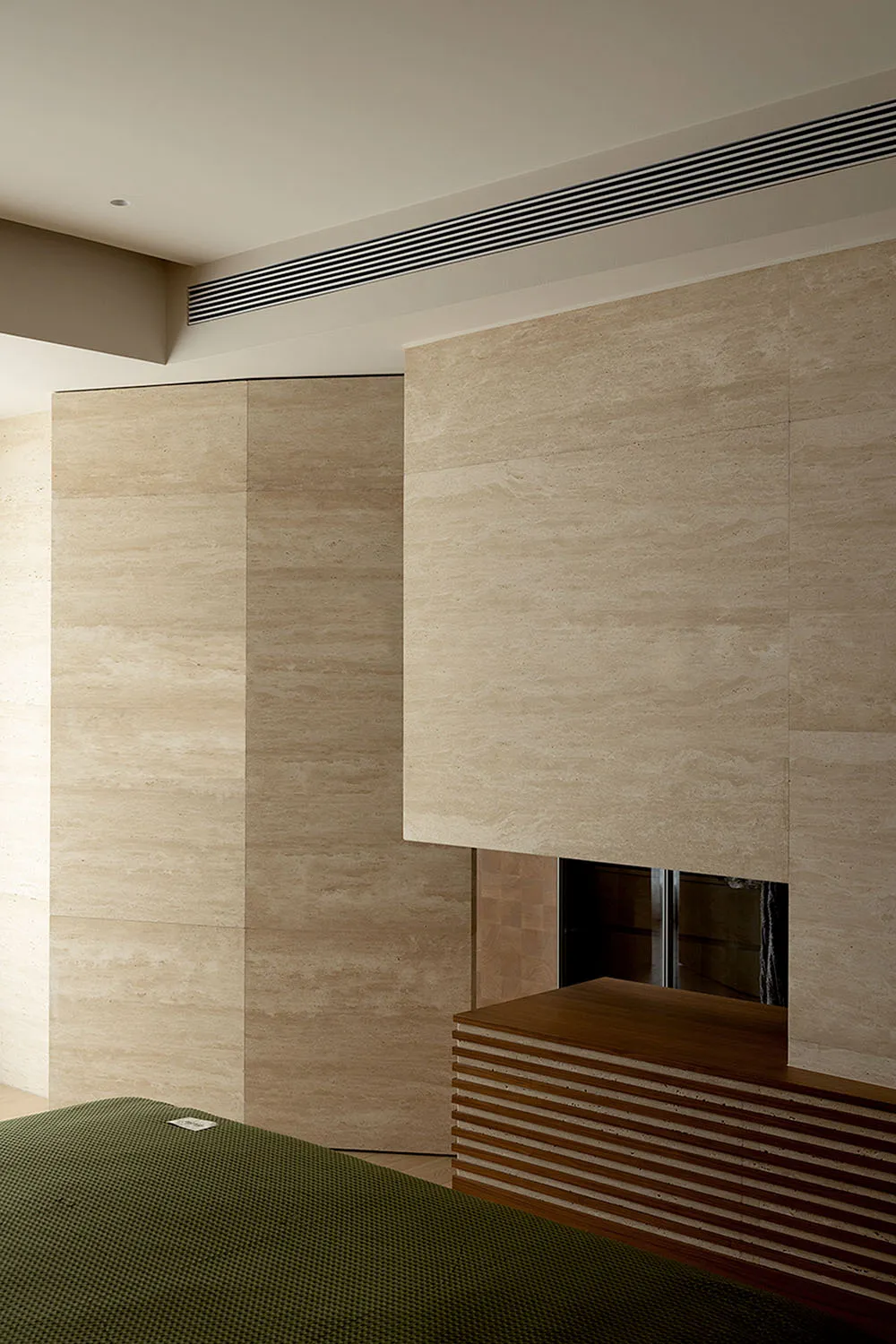 Modern, minimalist bedroom with marble walls and a wooden headboard.