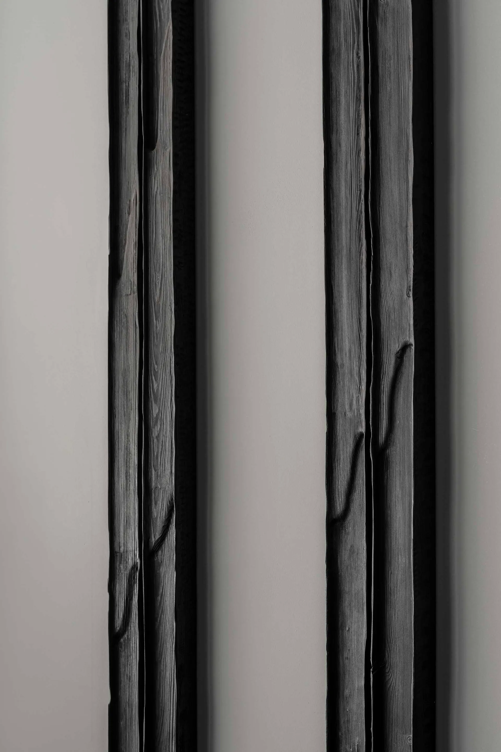 Vertical lines of dark wood panels against a neutral background